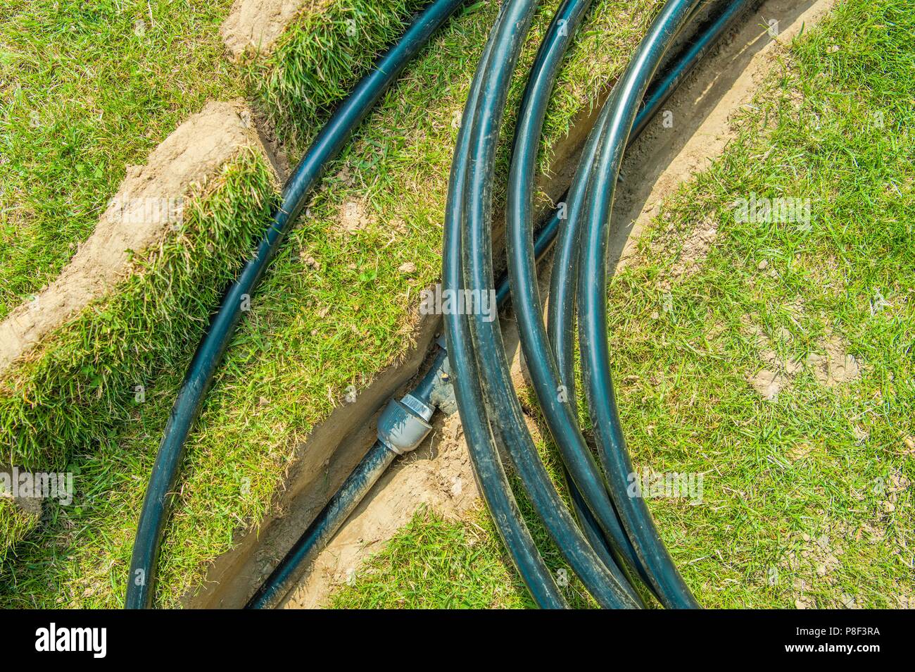 Unterirdische Bewässerungssystem Pipeline. Gebäude im Hinterhof Automatische Rasensprenger Wasserversorgung. Stockfoto