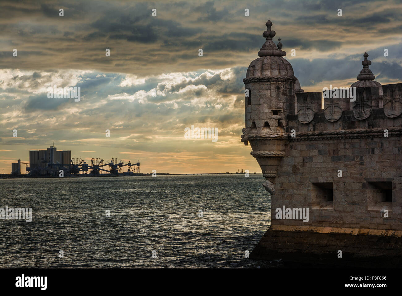 Vergangenheit und in Portugal. Alte Belem Turm Turm mit modernen Hafen Terminal am Meer, mit einem wunderschönen Sonnenuntergang Himmel Stockfoto