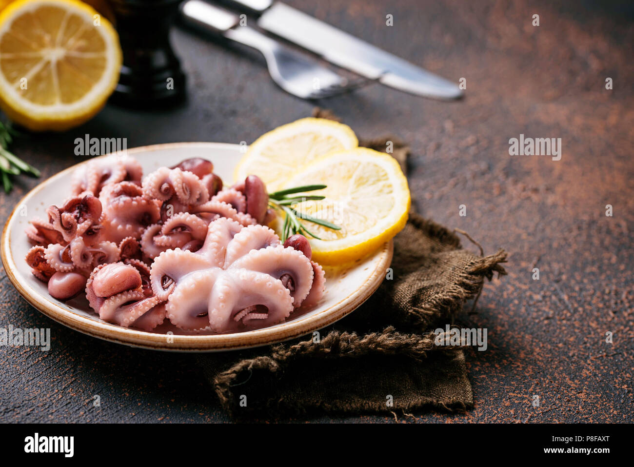 Tintenfische in der Platte mit Zitrone und Rosmarin Stockfoto