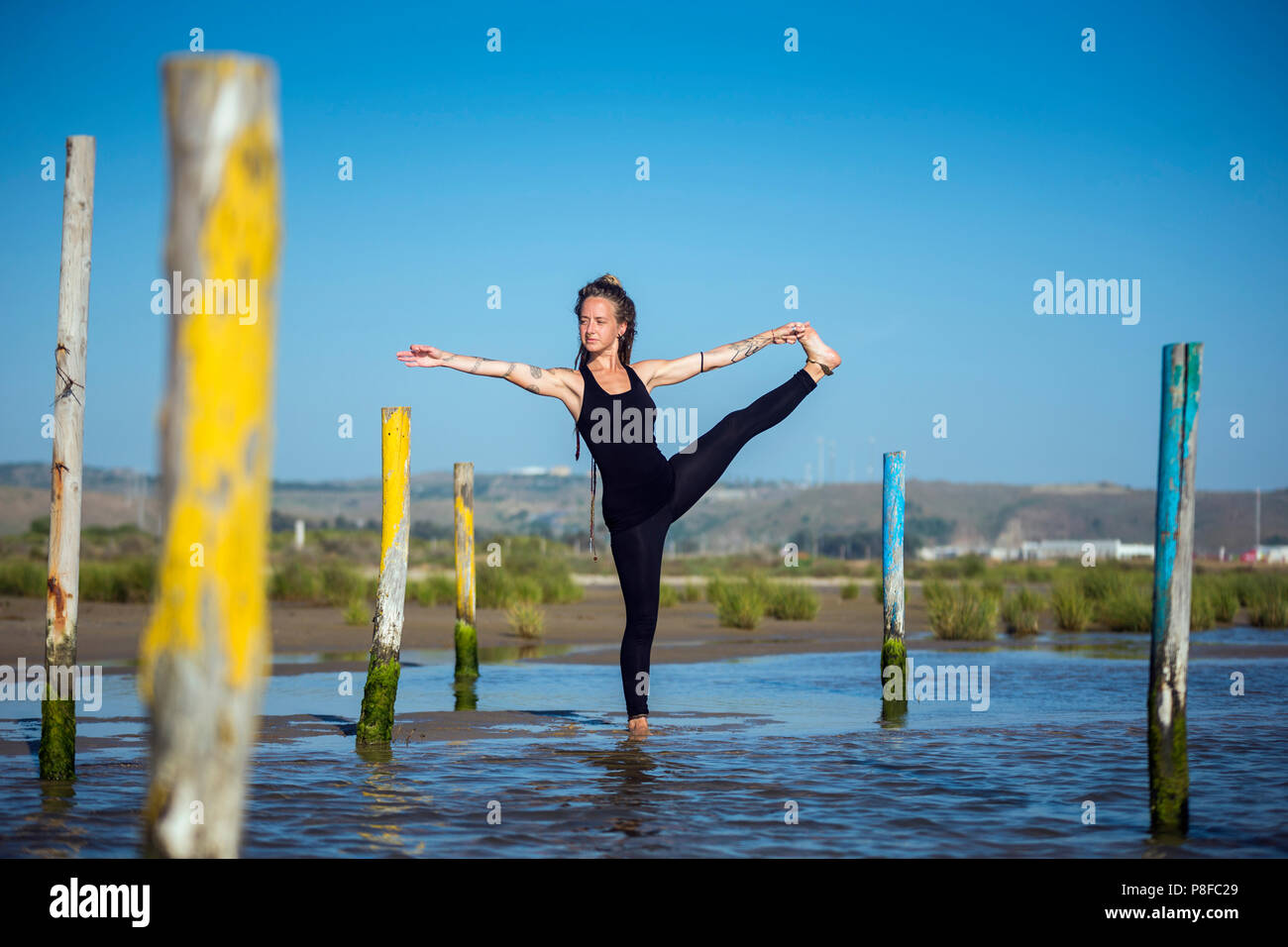 Frau tun, um eine Hand zu großen Zeh yoga Pose am Strand, Tarifa, Cadiz, Andalusien, Spanien Stockfoto