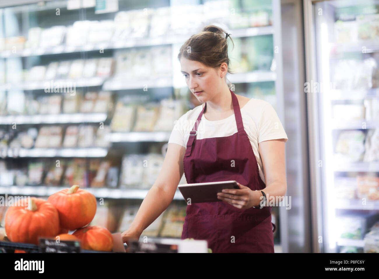 Supermarkt Verkäuferin Kontrolle mit Hilfe eines digitalen Tablet Stockfoto
