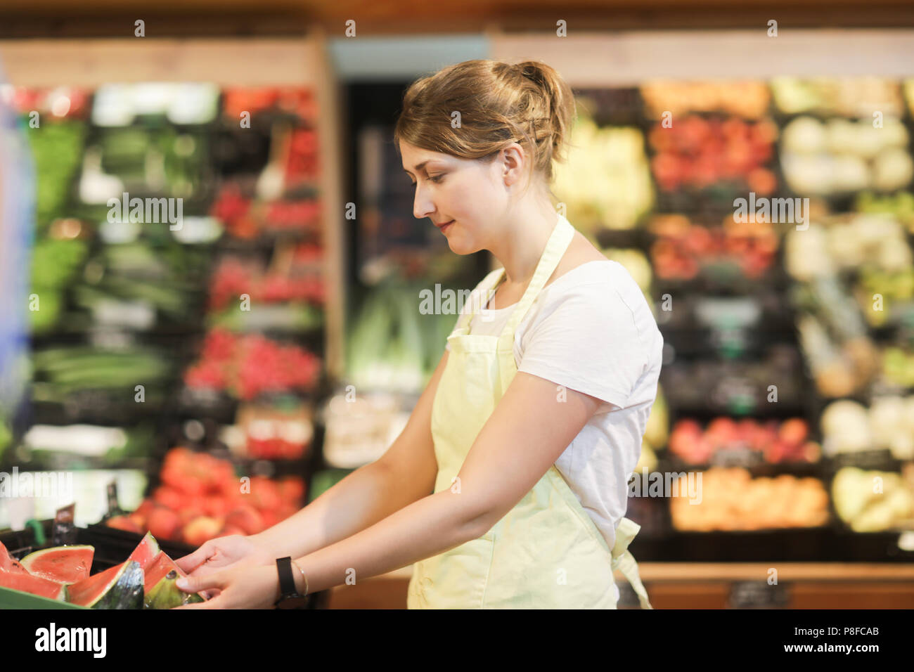 Sales Assistant arbeiten in der Obst- und Gemüseabteilung Stockfoto