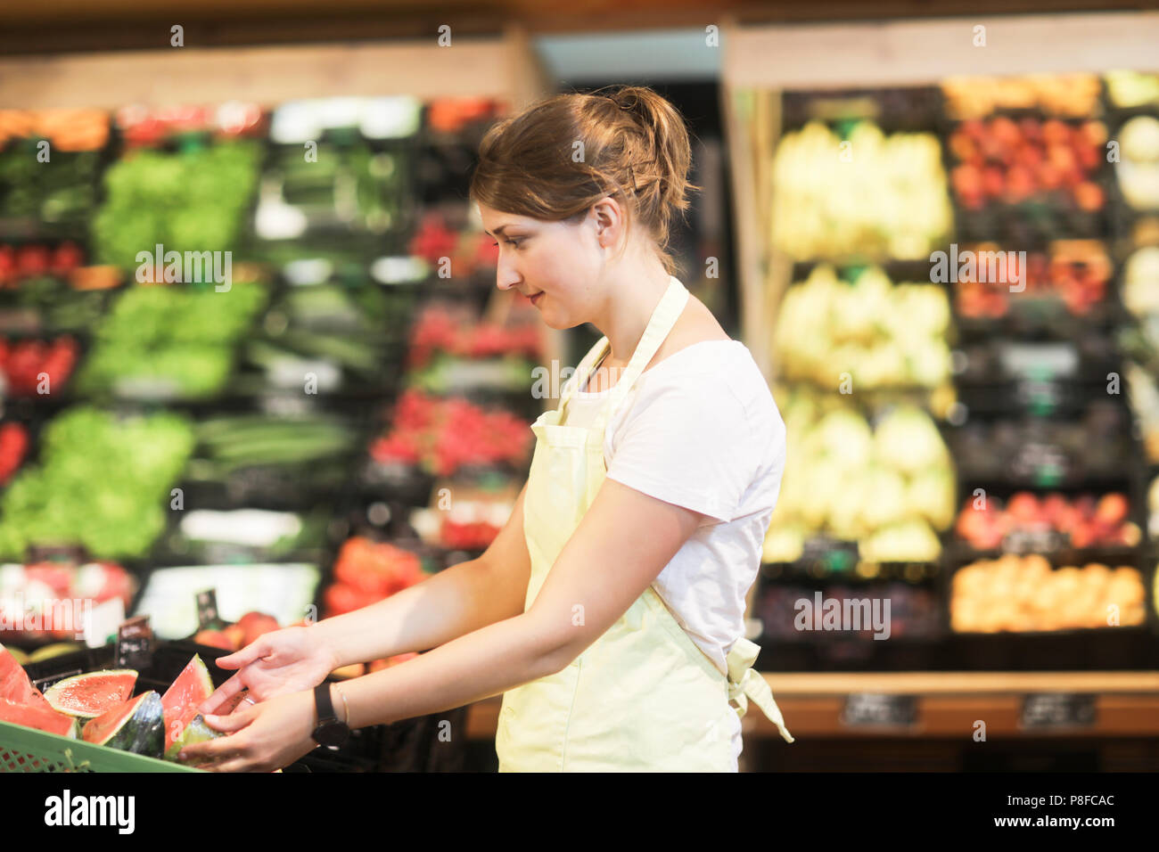 Sales Assistant arbeiten in der Obst- und Gemüseabteilung Stockfoto