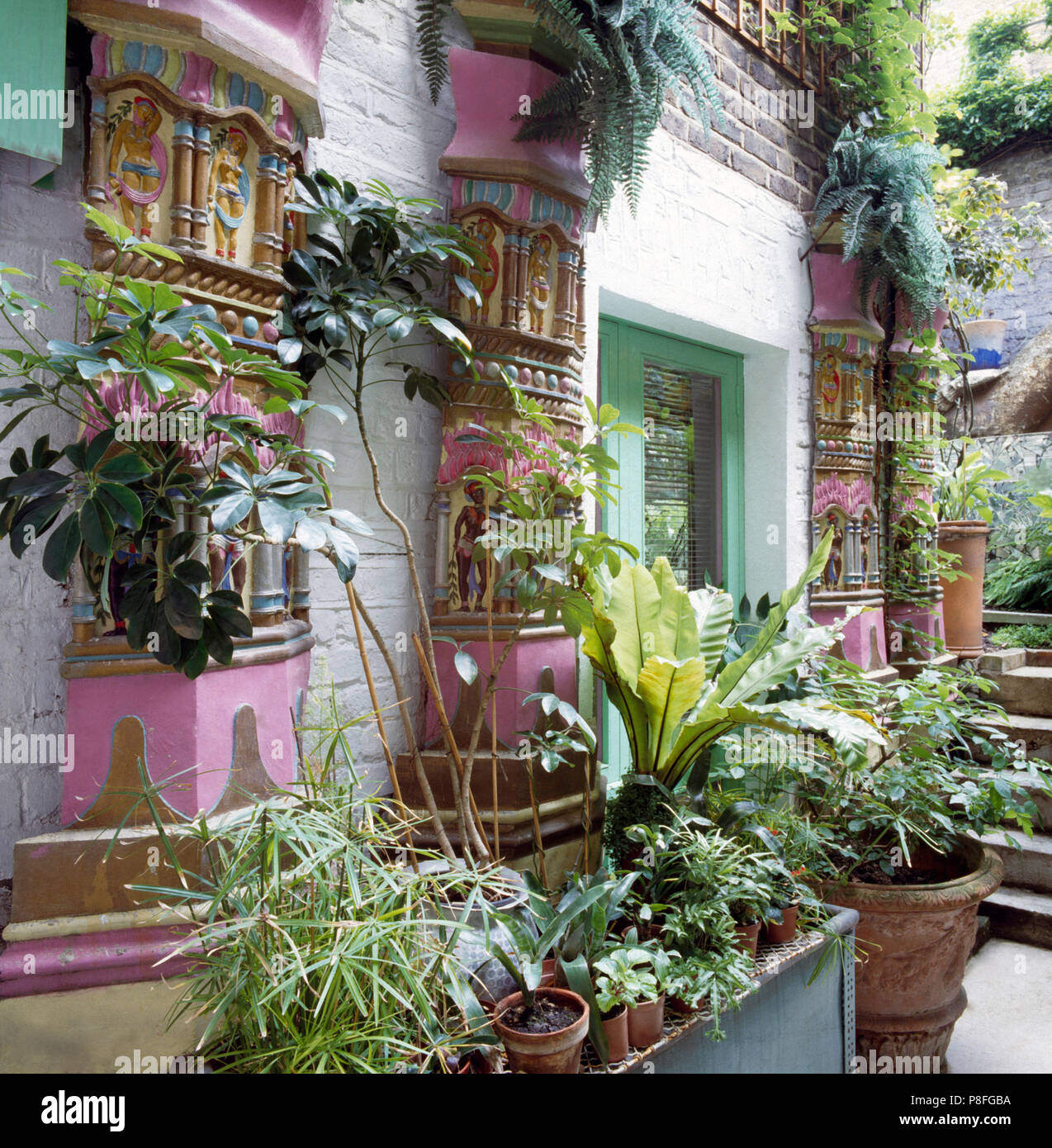 Fassade eines Hauses in der indischen Stil mit grünen Pflanzen in pflanzmaschinen an den Wänden und auf dem Boden Stockfoto