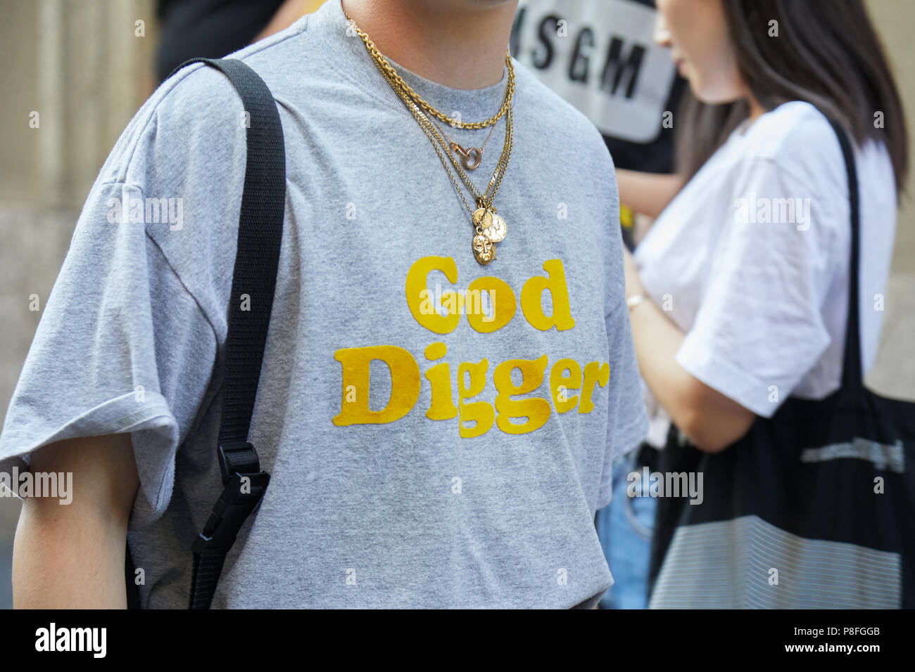 Mailand - 16. Juni: Mann mit goldenem neacklaces und Gott digger-t-shirt vor Versace fashion show, Mailand Fashion Week street style am 16. Juni 2018 in Mi Stockfoto