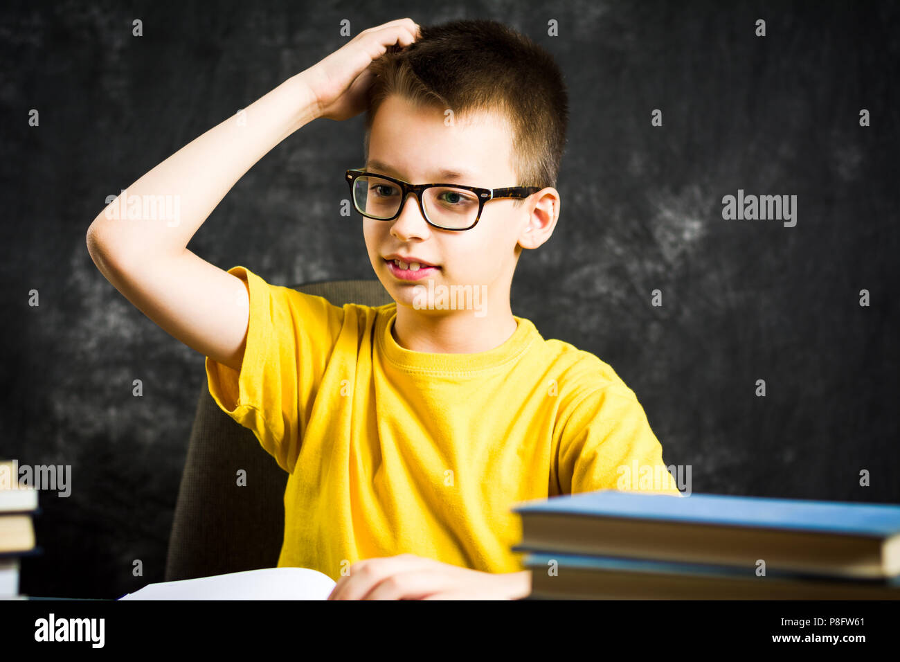 Fröhliche Junge mit Haufen Bücher über Schule denken, Bildung Abstract Stockfoto