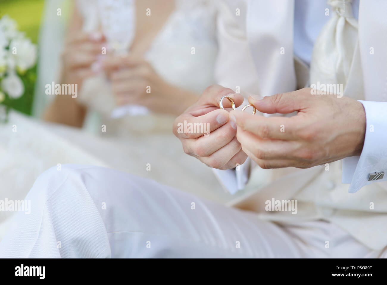 Bräutigam hält zwei goldene Hochzeit Ringe Stockfoto
