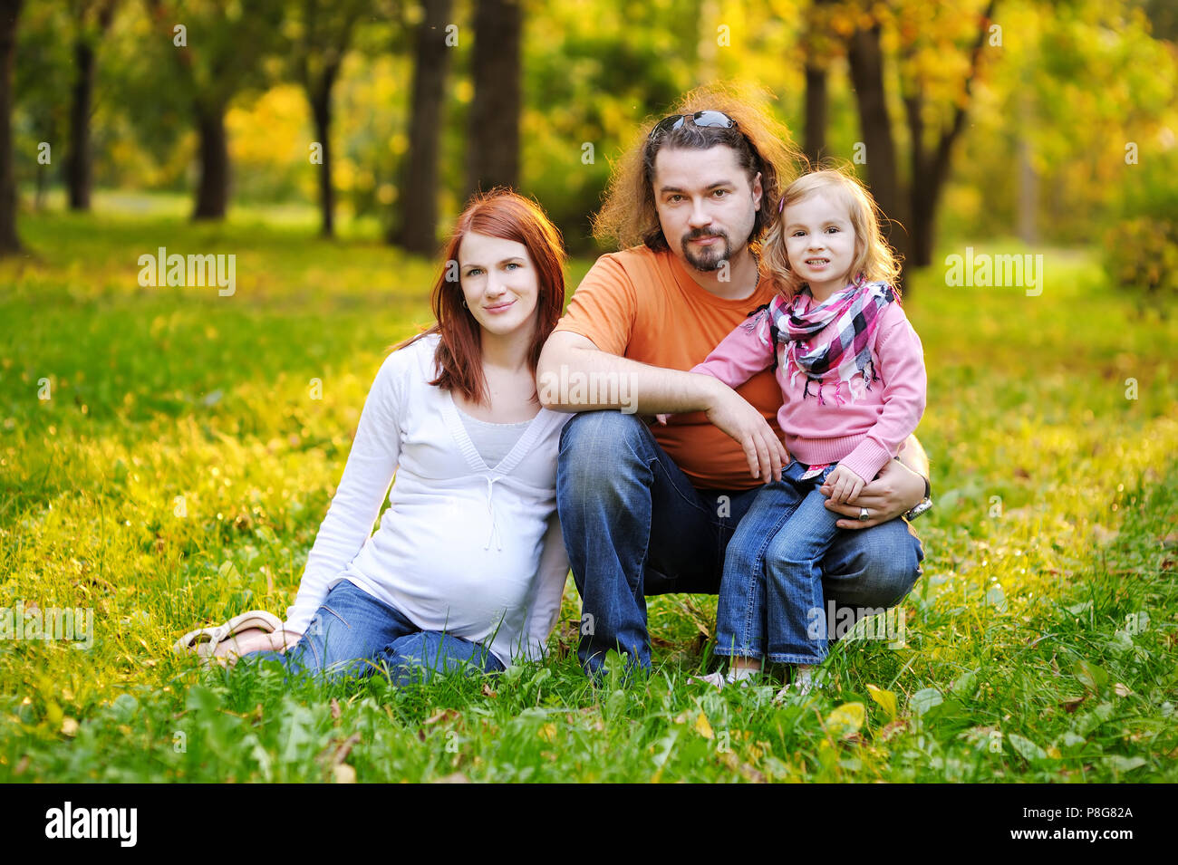 Schöne erwartet Familie im Herbst Park bei Sonnenuntergang Stockfoto