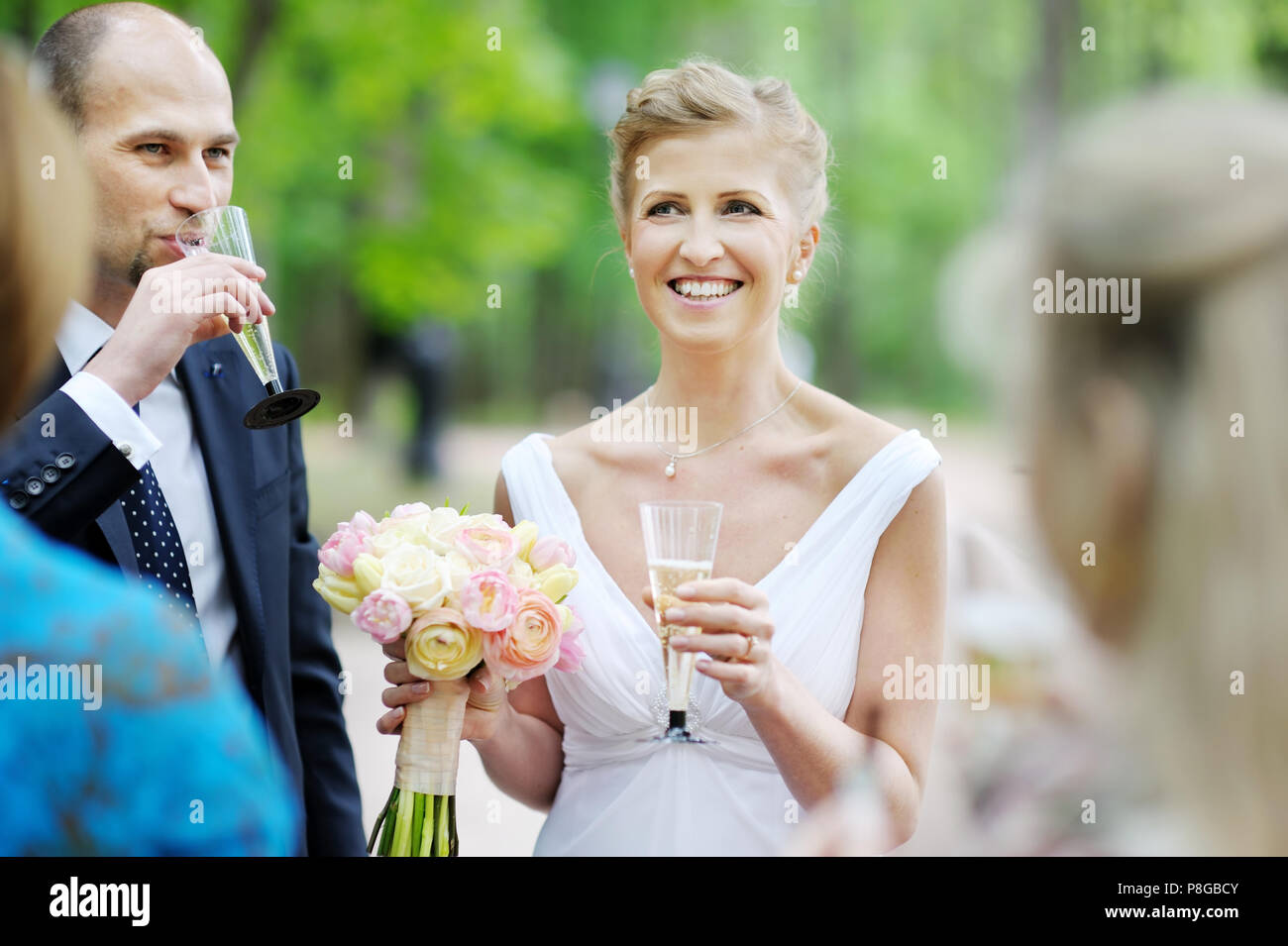 Hochzeitsgäste toasten glückliche Braut und Bräutigam Stockfoto