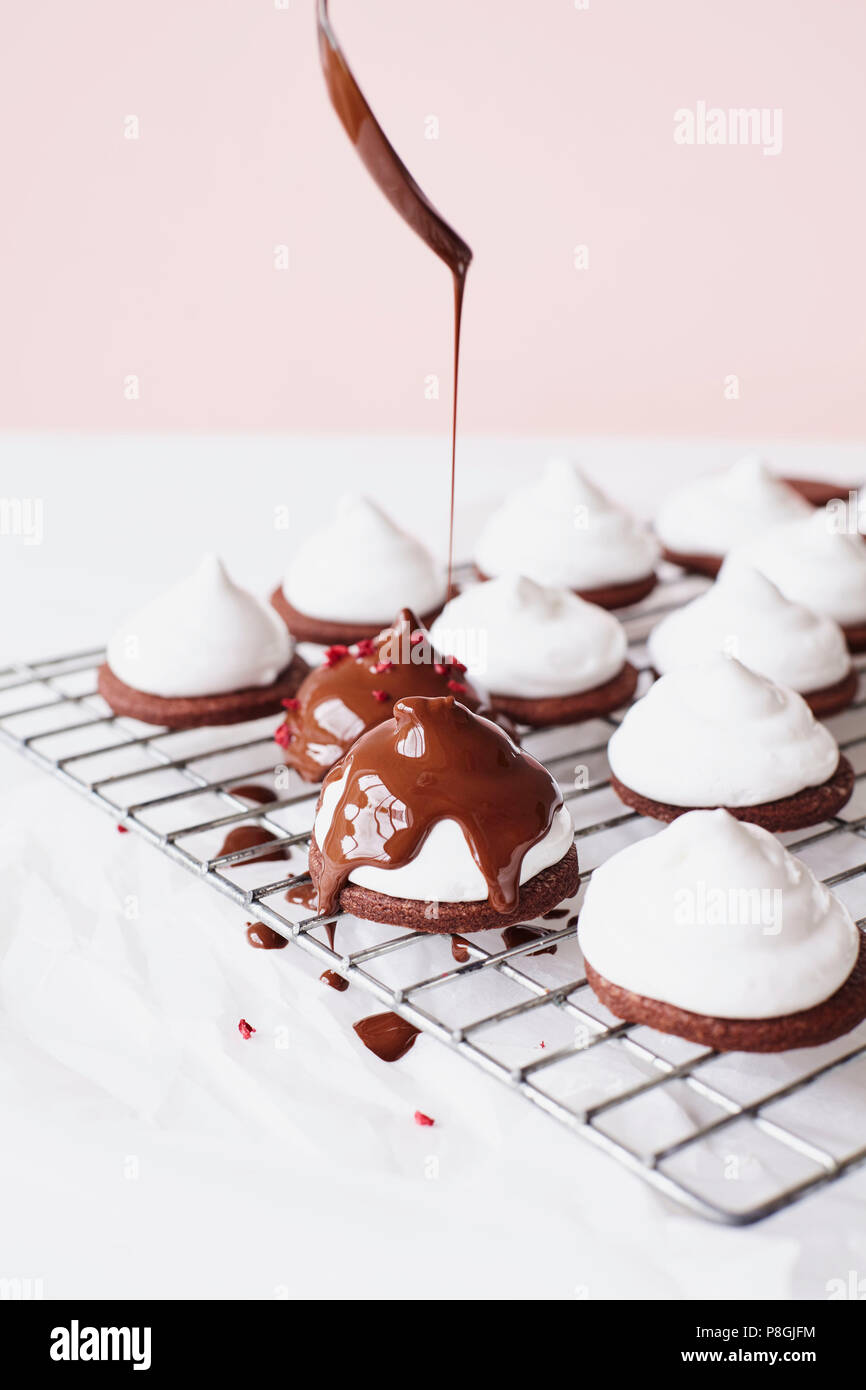 Nieselregen geschmolzene Schokolade auf Marshmallow Teacakes Stockfoto