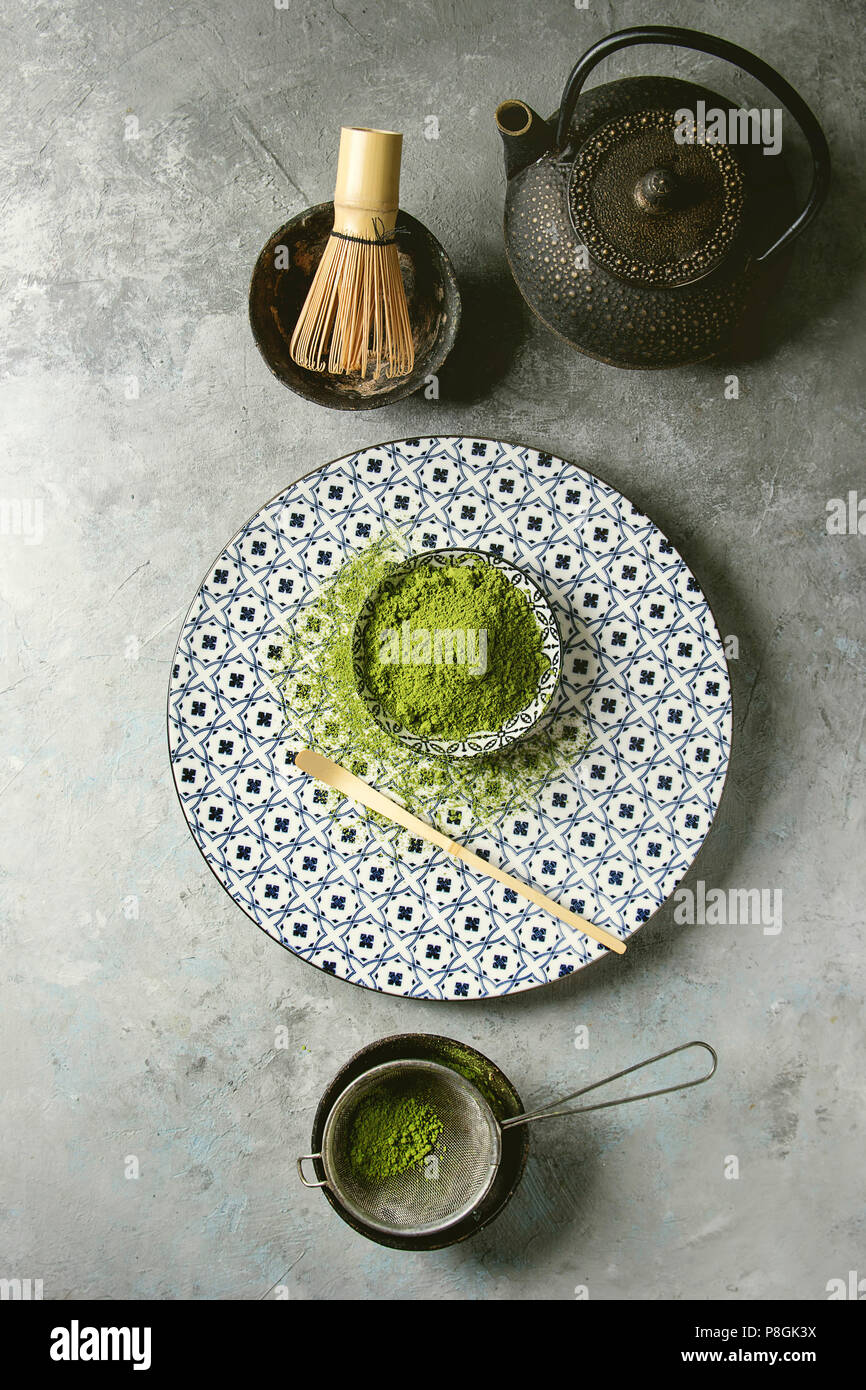 Zutaten fr die Herstellung von Matcha Tee trinken. Grner Tee matcha Pulver  in Keramik Schssel, traditionelle Bambus Lffel und Schneebesen auf  dekorative Platte, schwarz Eisen teapo Stockfotografie - Alamy