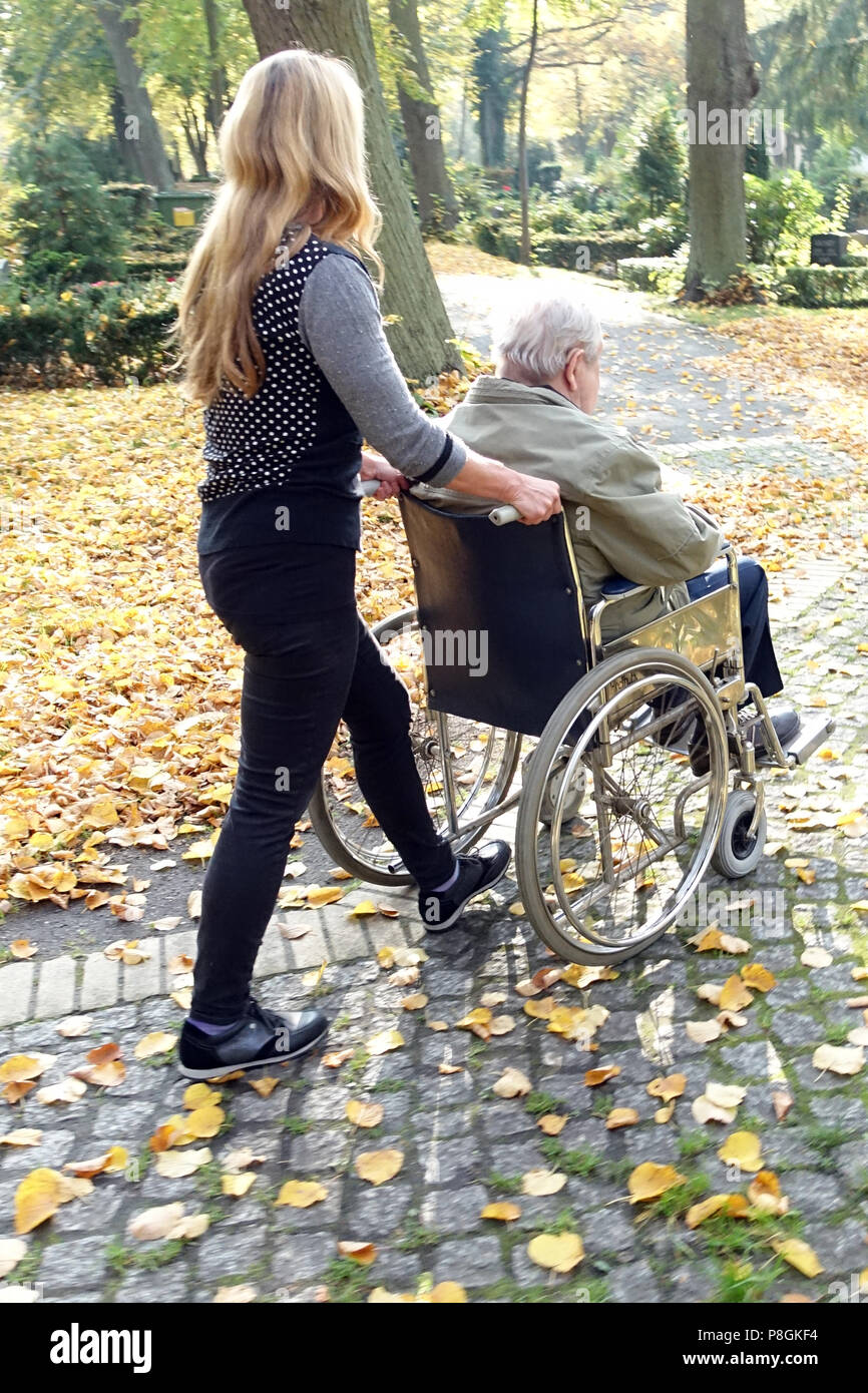 Berlin, Deutschland, Frau schiebt einen alten Mann im Rollstuhl Stockfoto