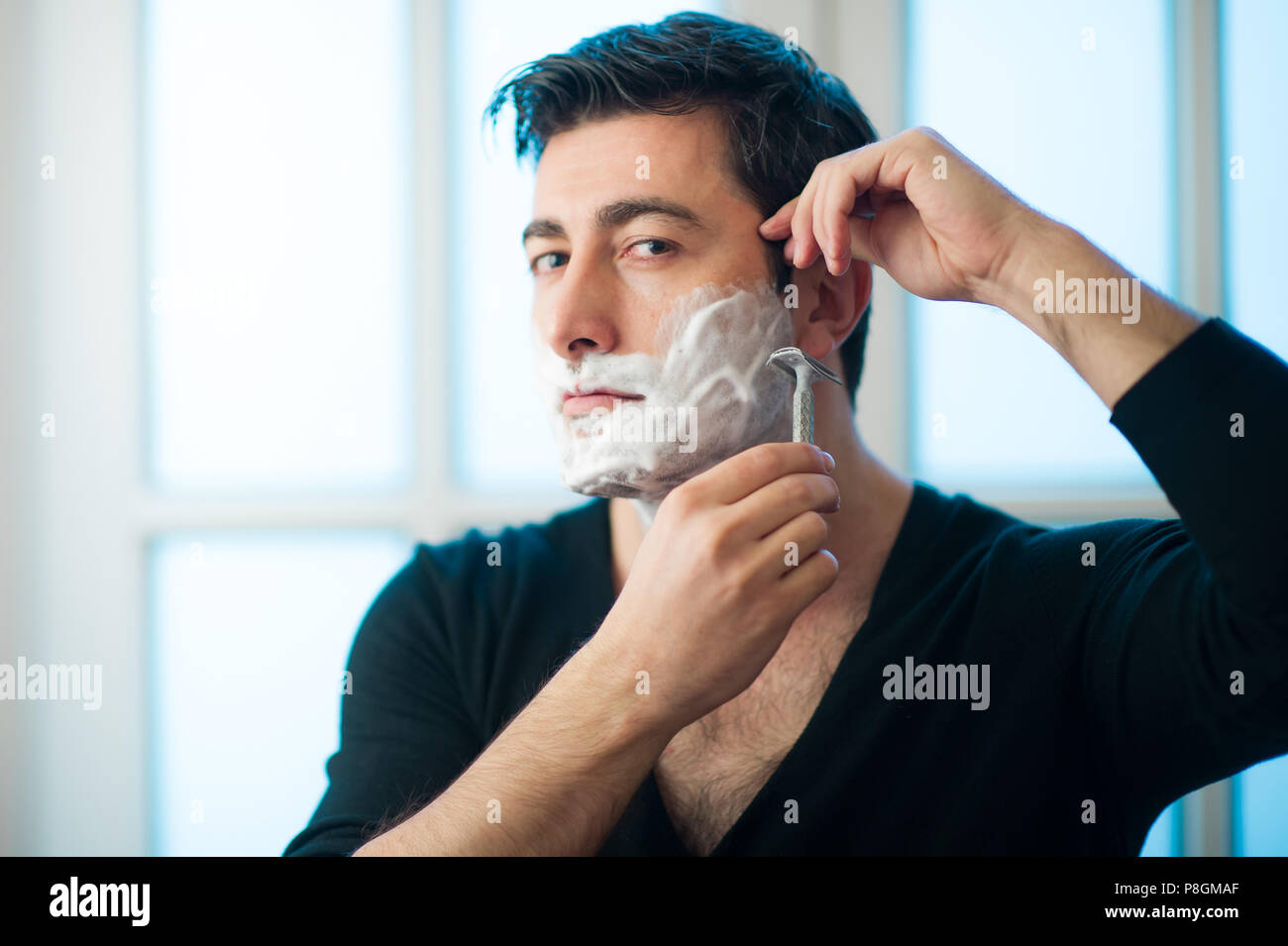 Junger Mann Rasieren mit dem Rasiermesser traditionelle Rasur Stockfoto