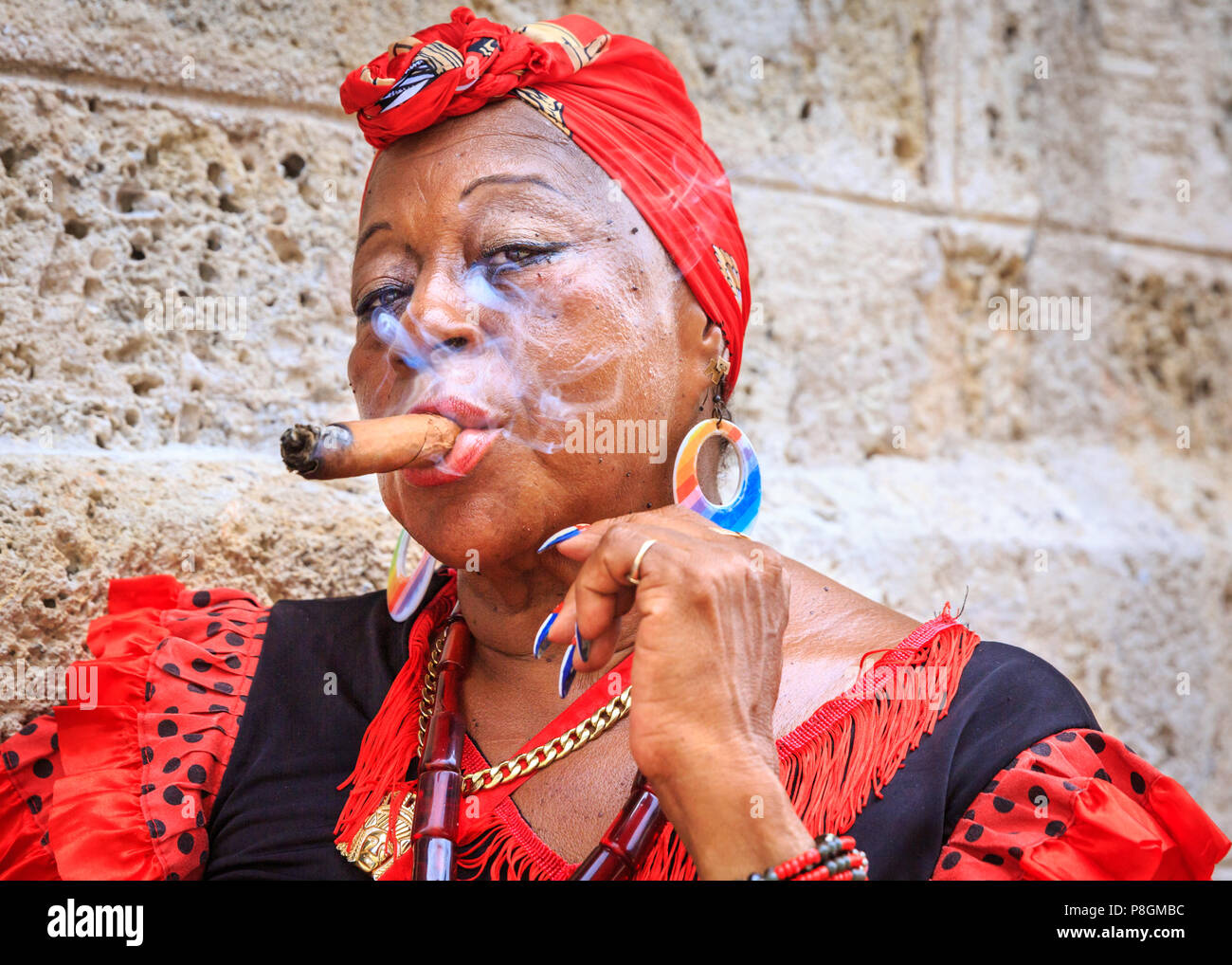 Kubanische Frau rauchen Zigarre, in traditioneller Kleidung, Blicke auf Kamera, Porträt, Havanna, Kuba Stockfoto