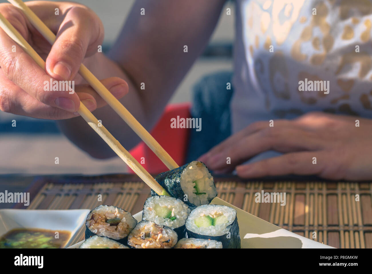 Frau mit Japan sticks isst Sushi in Street Cafe Stockfoto