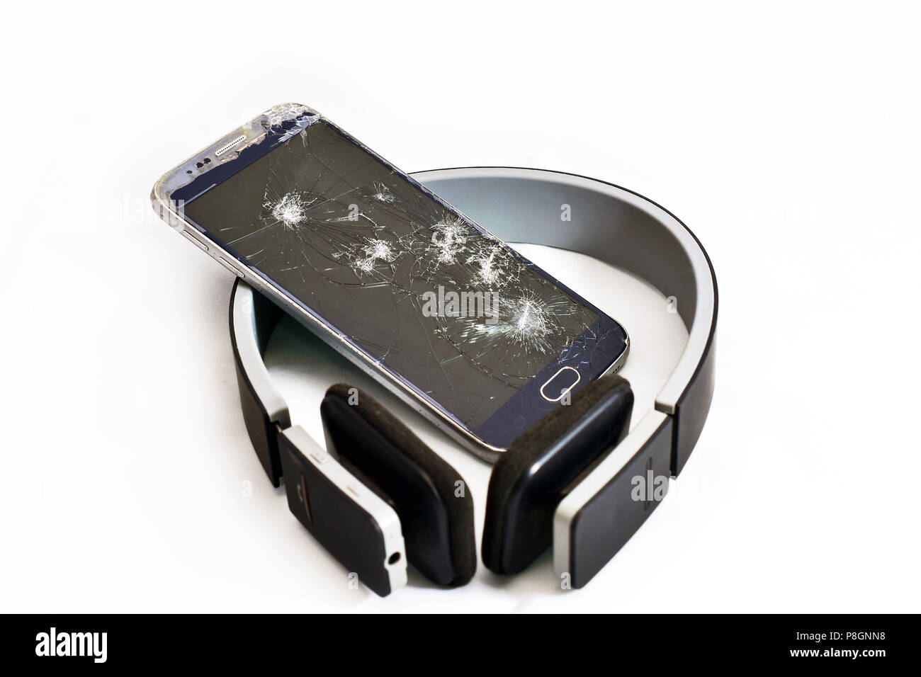 Ruinierte Handy mit Kopfhörer und zerbrochenes Display Stockfoto