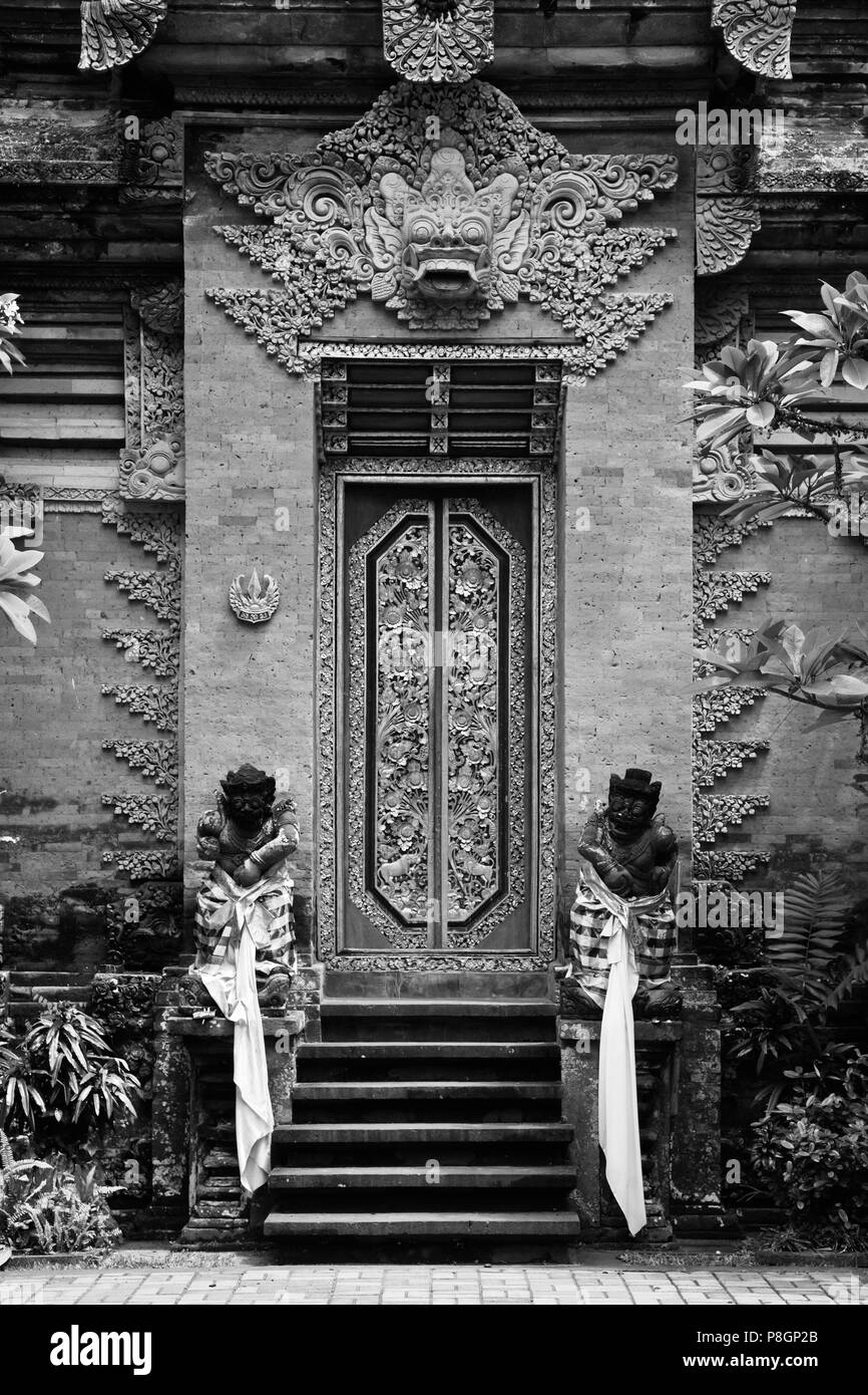 Kunstvolle Hand Carved Stone Gate mit barong Gesicht von PURA DESA UBUD, dem hinduistischen Tempel der Stadt - UBUD, BALI Stockfoto