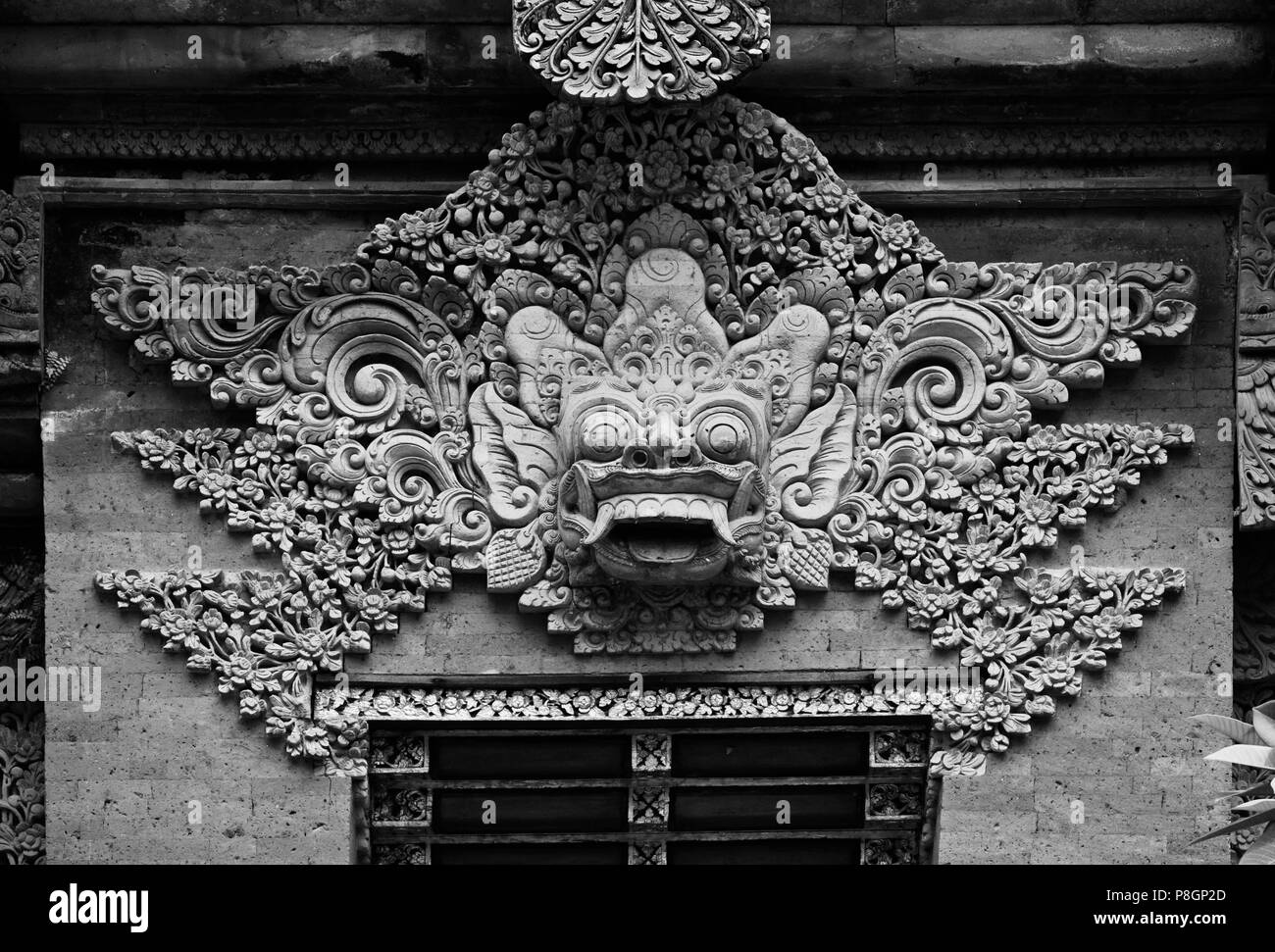 Kunstvolle Hand Carved Stone Gate mit barong Gesicht von PURA DESA UBUD, dem hinduistischen Tempel der Stadt - UBUD, BALI Stockfoto