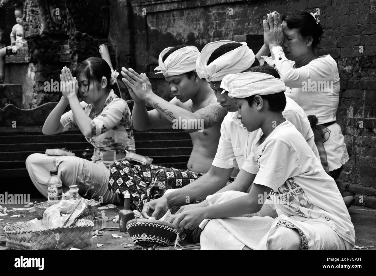 Eine balinesische Familie betet im PURA Tirta Empul einen hinduistischen Tempel Komplex und kalten Quellen mit Heilwasser - TAMPAKSIRING, Bali, Indonesien Stockfoto