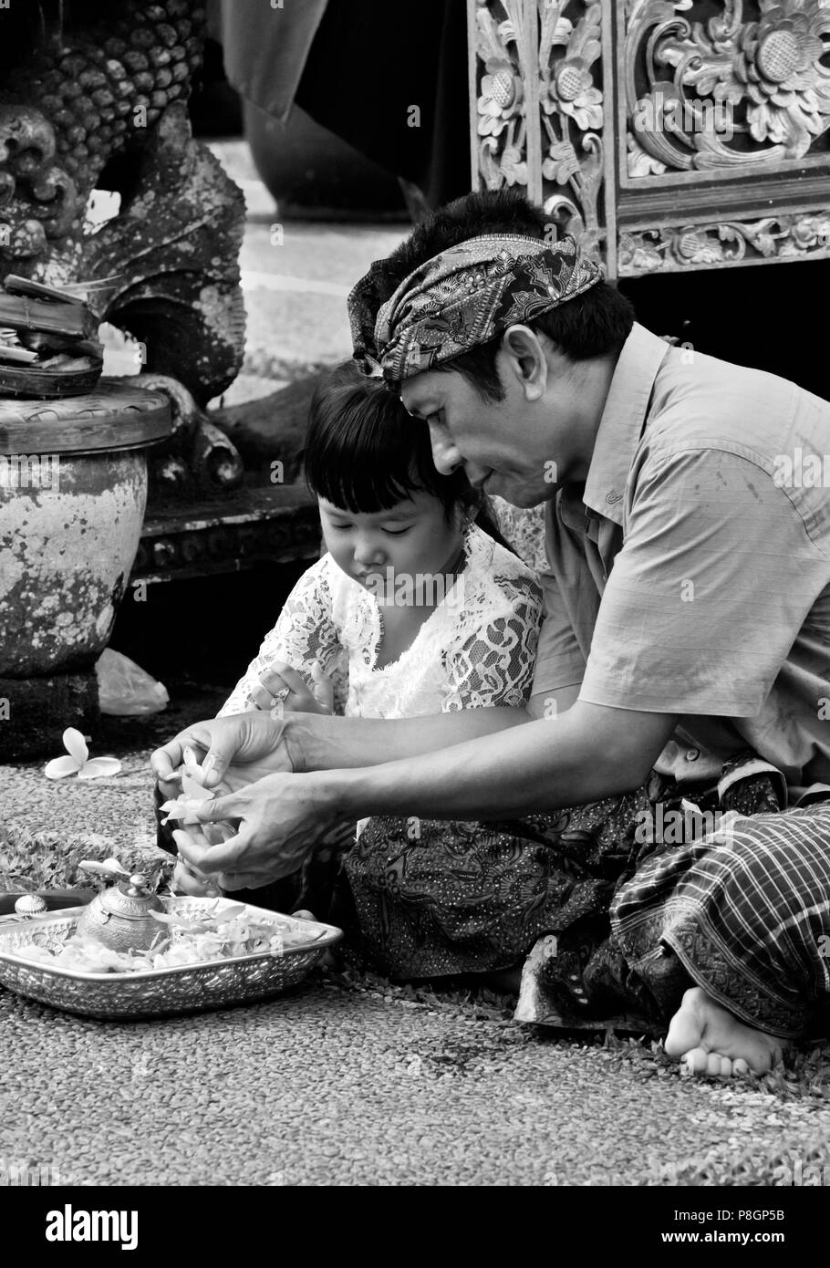 Vater und Tochter machen Puja in PURA TAMAN SARASWATI während der GALUNGAN FESTIVAL - UBUD, BALI, Indonesien Stockfoto
