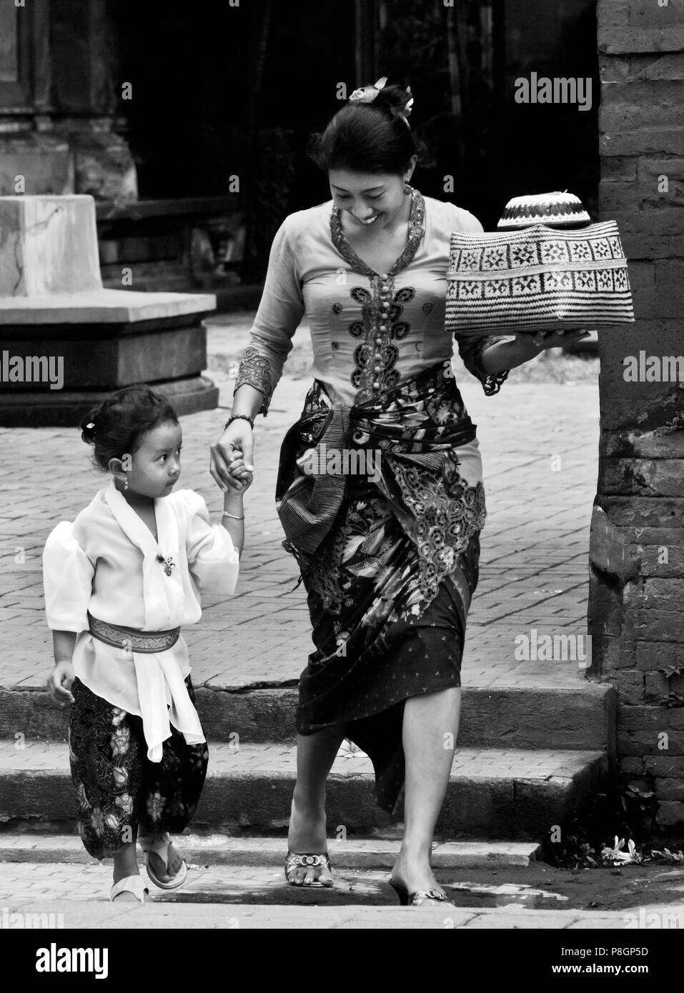 Balinesische Frau und Tochter tragen Angebote indie Hindu Tempel Pura DESA während des Fest Galungan FESTIVAL - Ubud, Bali, Indonesien Stockfoto