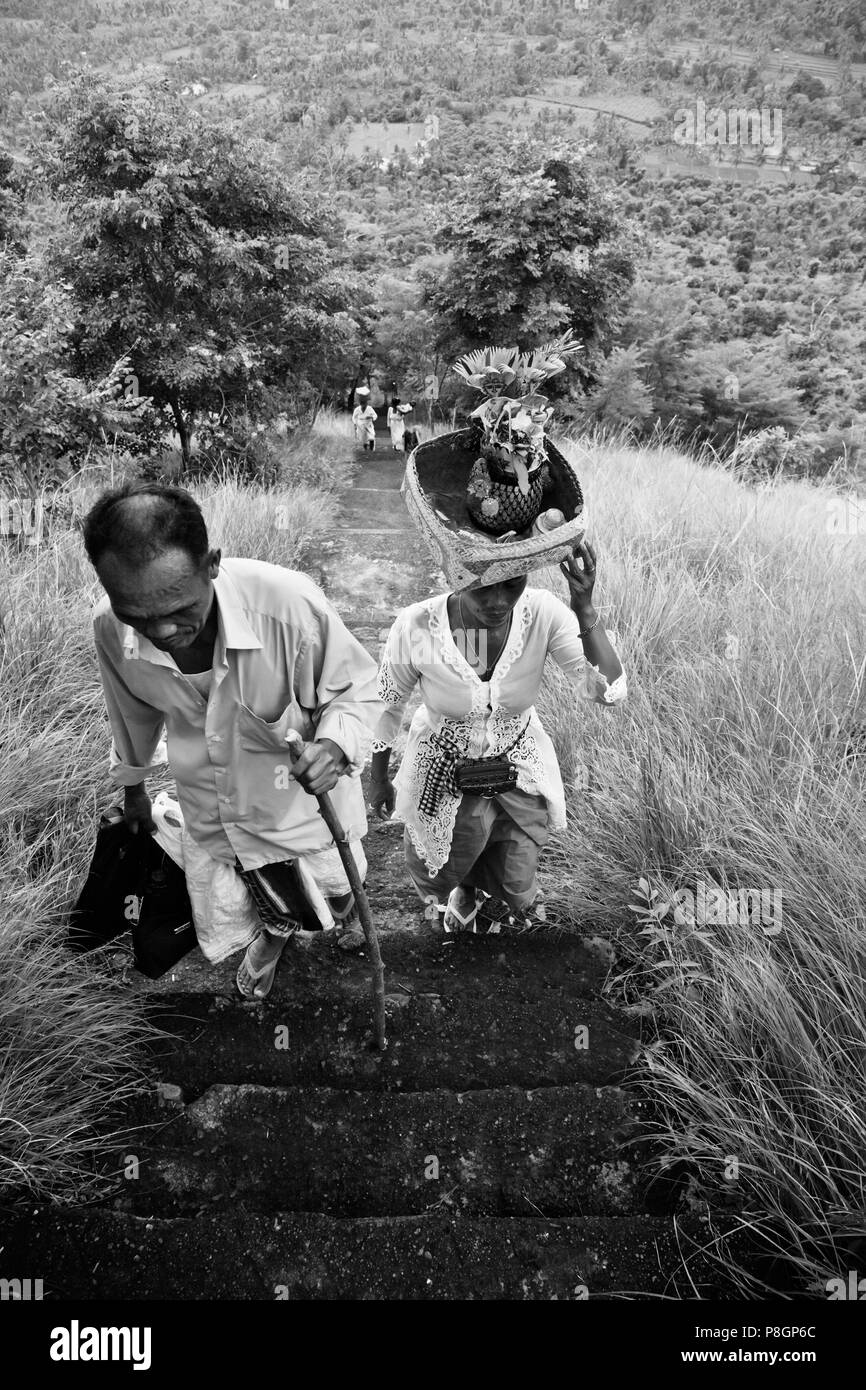 Balinesische DEVOTEES Treppen zu einem remote Hindu Tempel auf einem Hügel oberhalb einer Landwirtschaft Tal in der Nähe von pemuteran - Bali, Indonesien Stockfoto