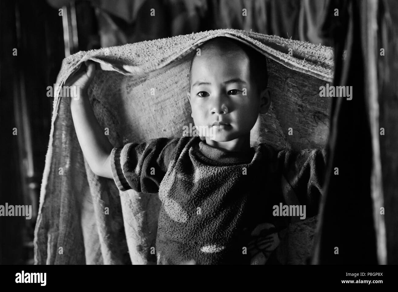 Ein kleiner Junge der AKHA in seinem Haus in einem Dorf in der Nähe von KENGTUNG oder KYAINGTONG - MYANMAR Stockfoto