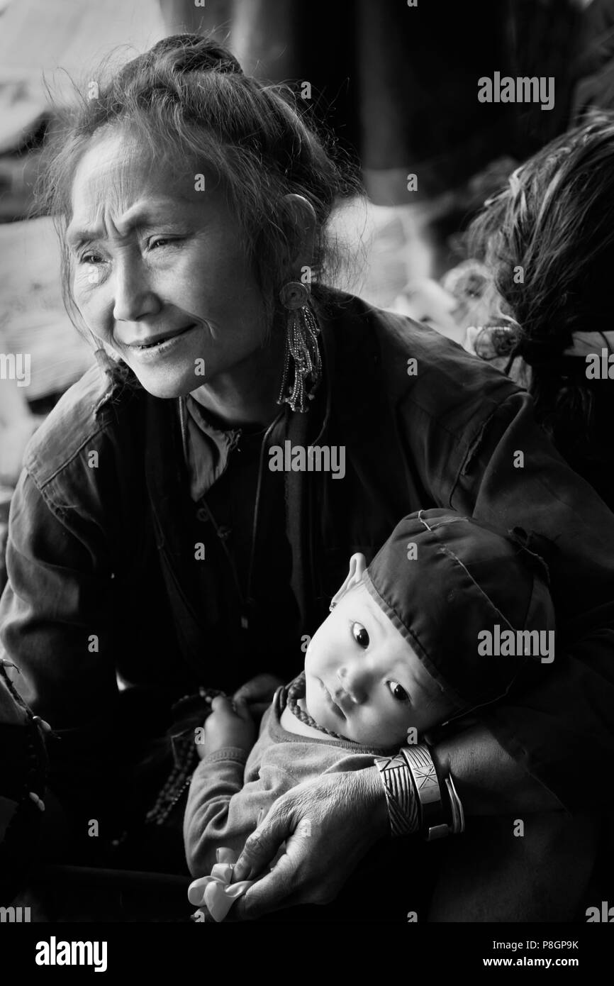 Eine ANN TRIBAL Frau mit ihrem Enkel in traditioneller Kleidung in ihrem Dorf in der Nähe von KENGTUNG auch bekannt als KYAINGTONG - MYANMAR Stockfoto
