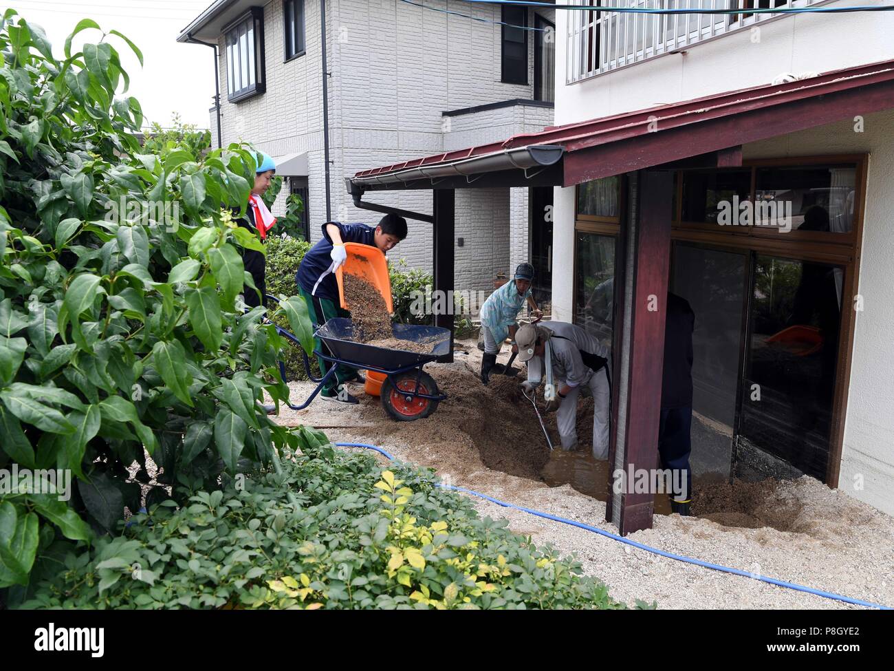 Hiroshima, Japan. 11. Juli 2018. Menschen klar eine überflutet Haus in Kure, Hiroshima, südwestliche Japan, 11. Juli 2018. Die Zahl der Todesopfer Nach den sintflutartigen Regenfällen Rammbock westlichen Japan und zu verheerenden Überschwemmungen und tödlichen Erdrutschen erreicht 176 am Mittwoch, sagten die Behörden. Quelle: Ma Ping/Xinhua/Alamy leben Nachrichten Stockfoto