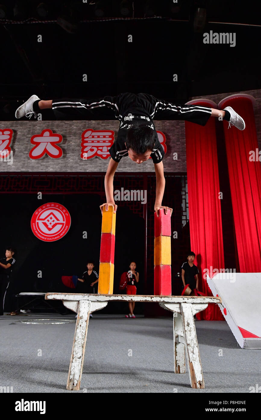 Puyang, Provinz Henan in China. 11. Juli 2018. Ein Praktikant hat gymnastische Übungen an einem akrobatik Schule in Dongbeizhuang Dorf Puyang, Chinas Provinz Henan, 11. Juli 2018. In Dongbeizhuang Dorf, eine akrobatik Schule schreibt etwa 40 Auszubildenden zwischen 5 und 15, die mit finanziellen Schwierigkeiten konfrontiert sind. Die Schule bietet beide Skills Trainings und akademische Lektionen, aber Gebühren keine Studiengebühren, die Vorbereitung der Auszubildenden größere Truppen und mehr Möglichkeiten zu verbinden. Credit: Feng Dapeng/Xinhua/Alamy leben Nachrichten Stockfoto