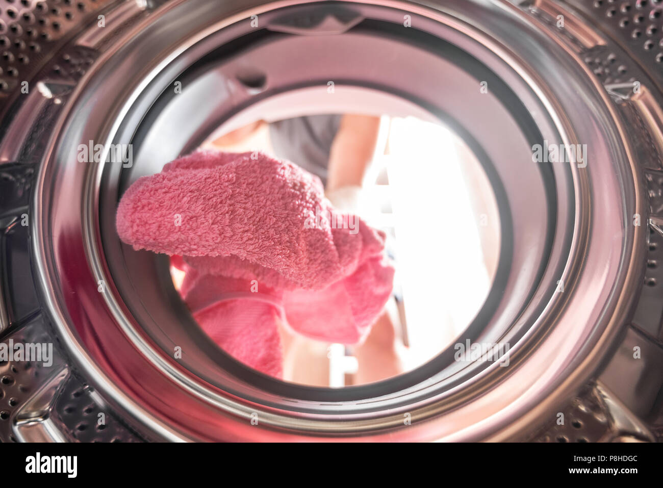 Junger Mann Wäsche Blick von der Innenseite der Waschmaschine Stockfoto