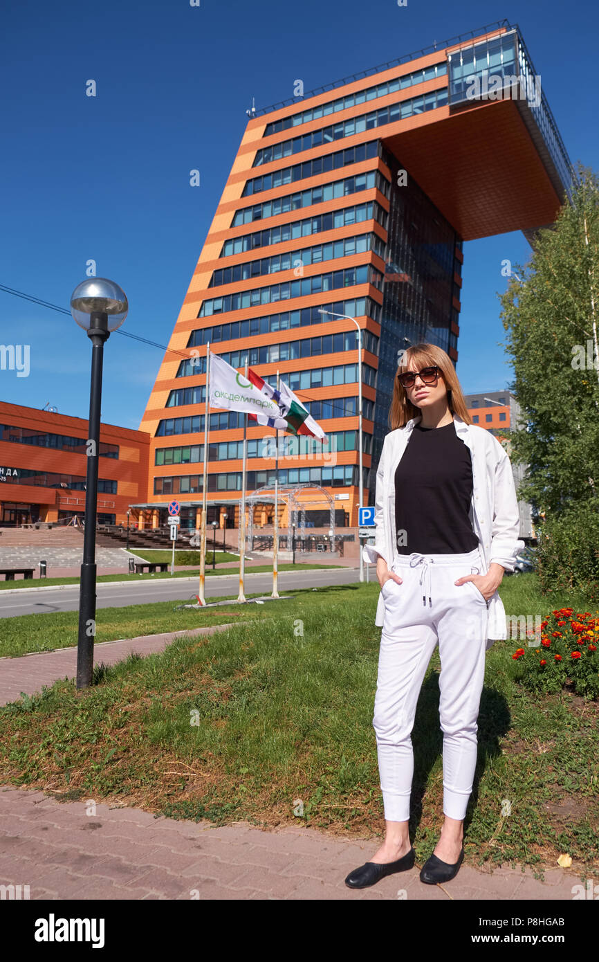 NOVOSIBIRSK AKADEMGORODOK, Russland - September 03, 2017: Moderne junge Frau in weißen Kleidern in der Nähe von Gebäude der Information Technology Center in Akademgo Stockfoto