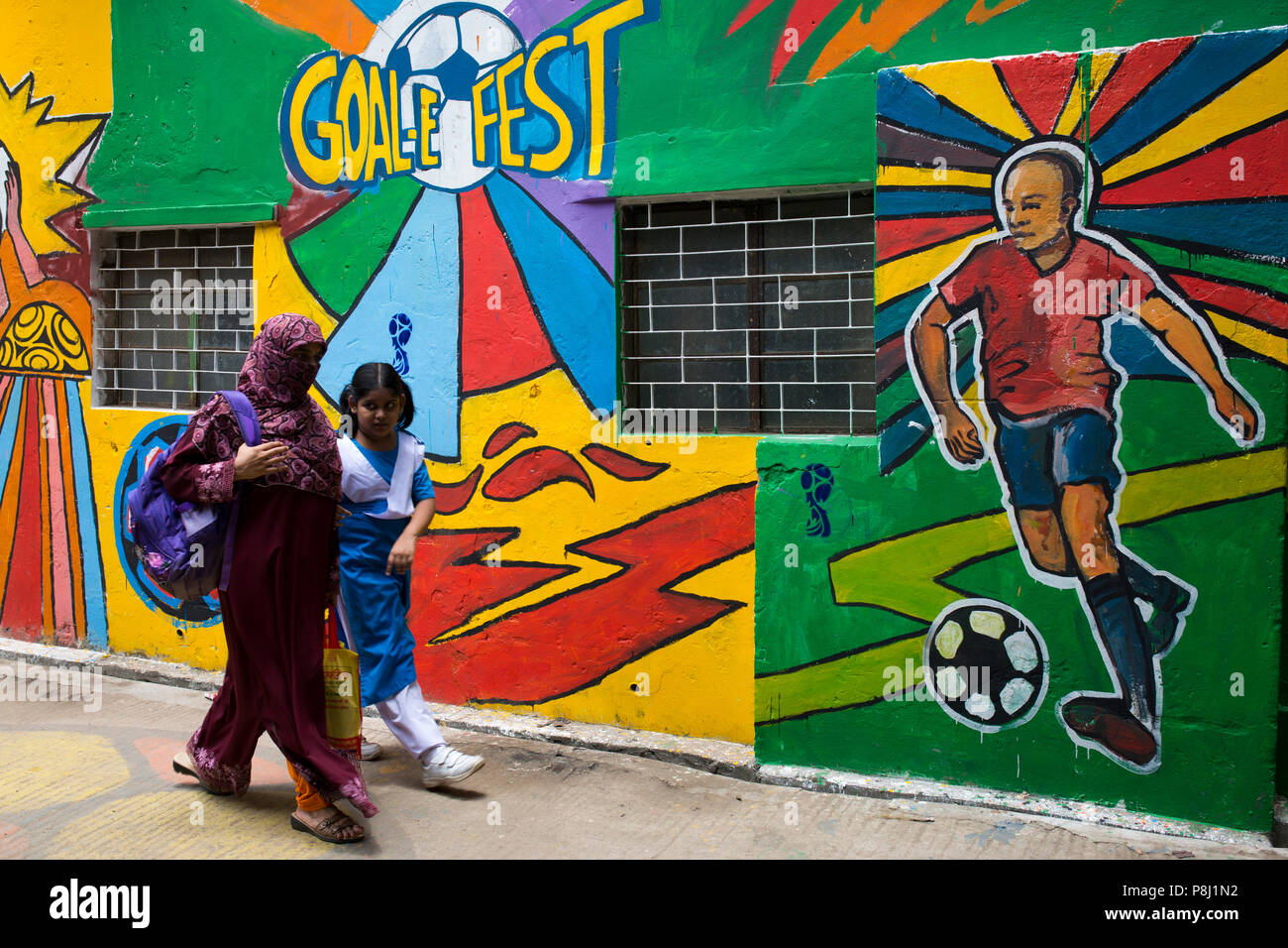 DHAKA, BANGLADESCH - Juli 10: Bangladesch Menschen Spaziergänge durch Neben einer Mauer mit Fußballfans während der FIFA WM 2018 in Russland gemalt in Dhaka Stockfoto