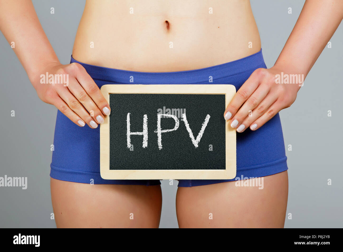 Die Gesundheit der Frauen. Junge Frau hält eine kleine Schiefertafel mit "HPV" Inschrift Stockfoto