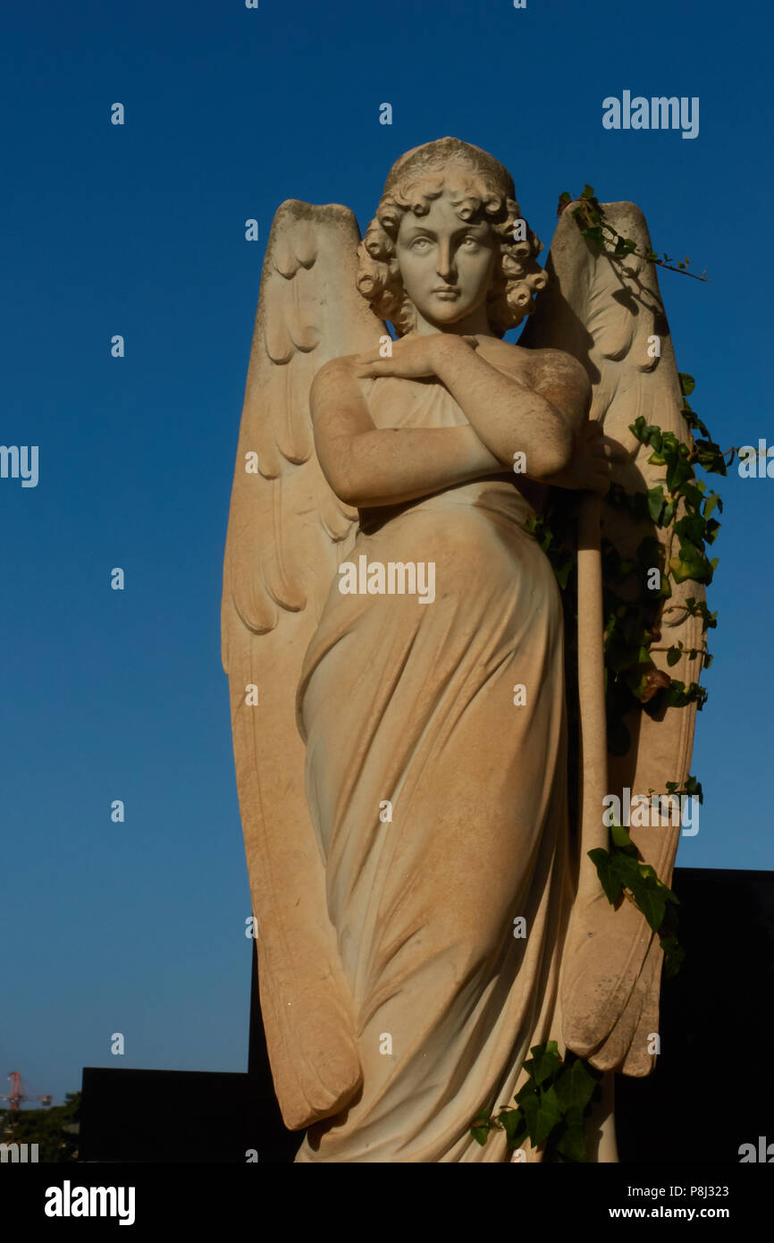 Eine Statue von einem wunderschönen Mädchen oder Engel in der addolorata Cemetery, Malta, mit einem klaren blauen Himmel hinter ihr Stockfoto