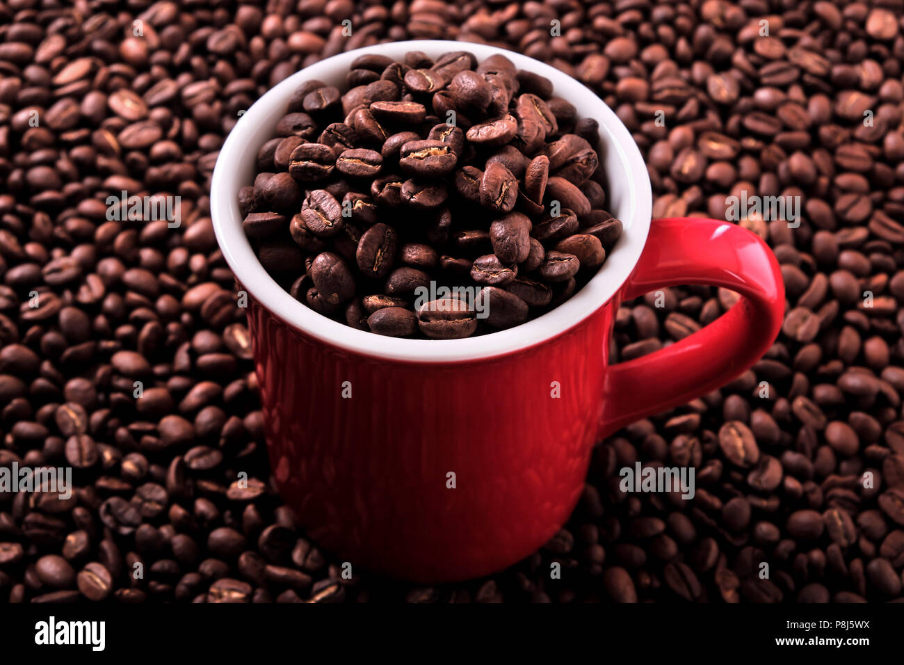 Rote Kaffeetasse mit Bohnen gefüllt Stockfoto