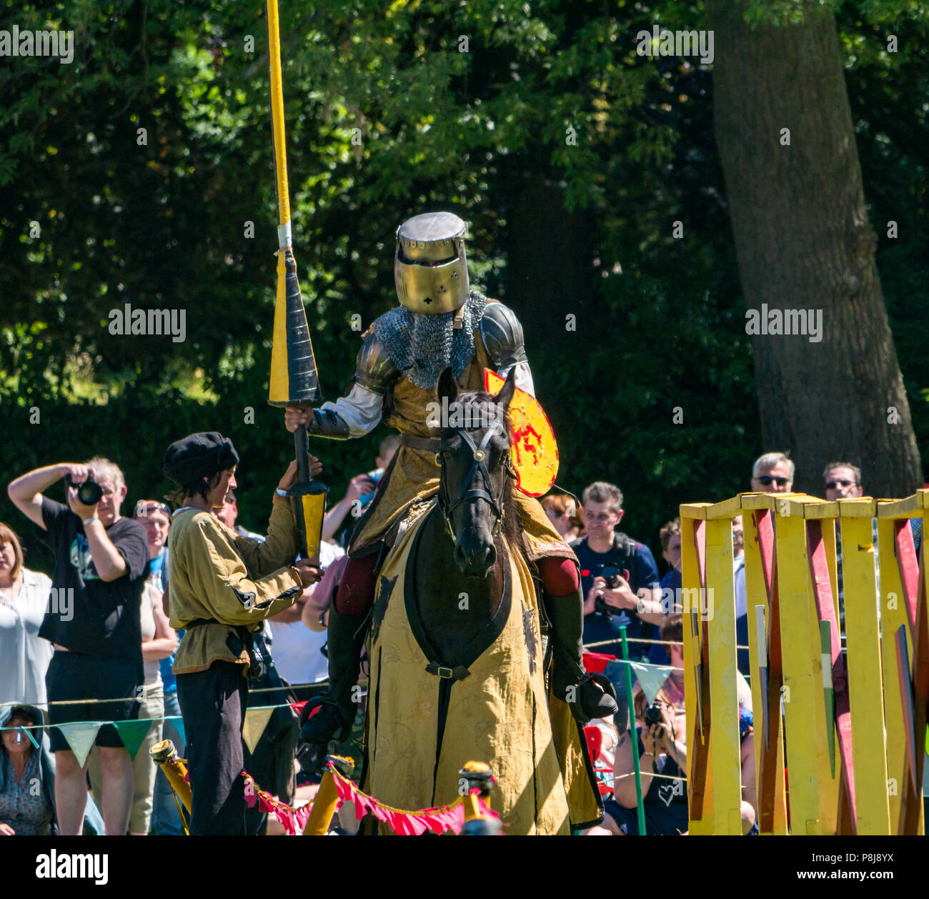 Medieval Jousting, Linlithgow Palace, Schottland, Großbritannien. Sommer Unterhaltung von Les Amis D'Onno equine stunt Team. Ein Ritter auf Pferd ist eine Lanze übergeben Stockfoto