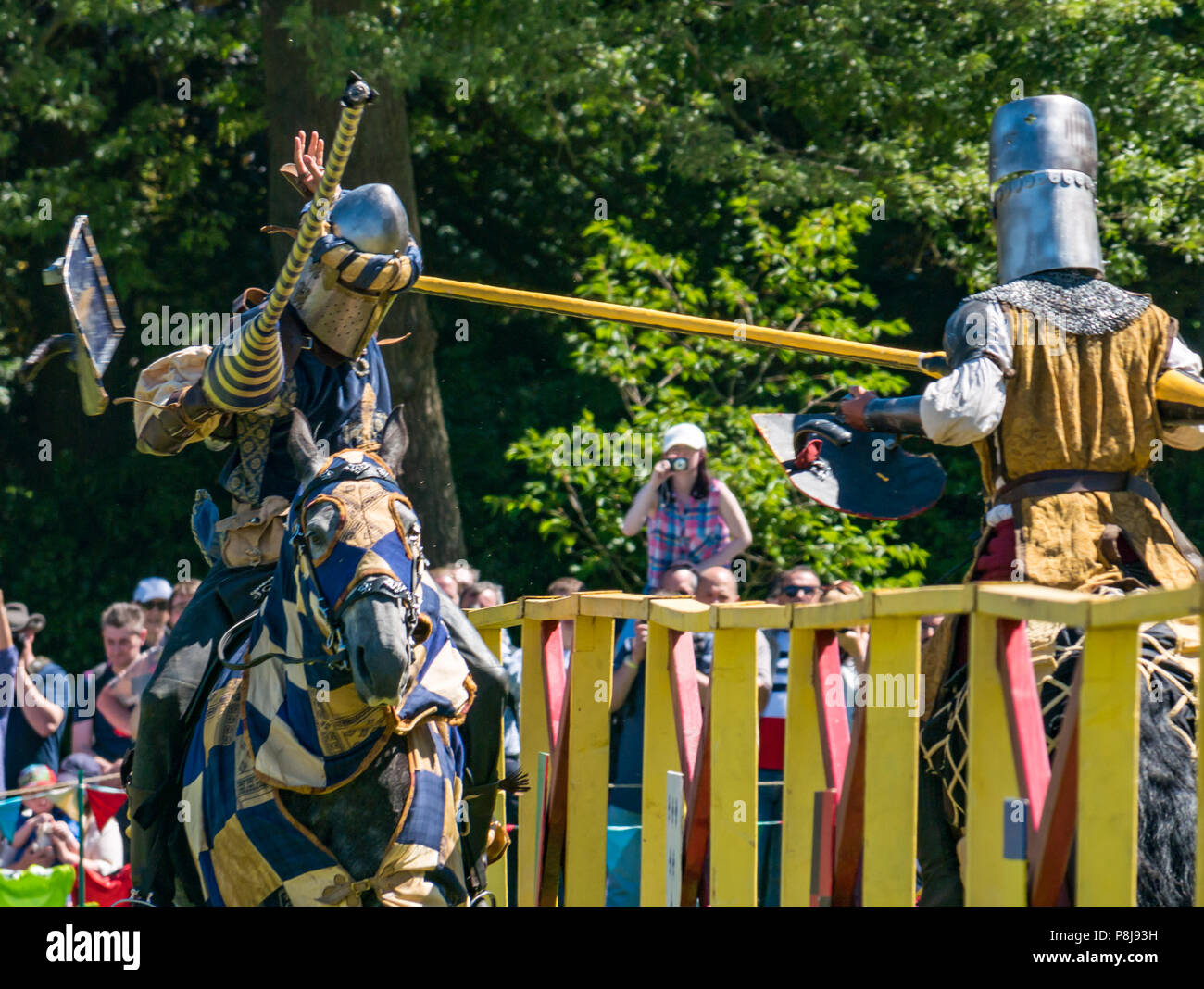 Medieval Jousting, Linlithgow Palace, Schottland, Großbritannien. Sommer Unterhaltung von Les Amis D'Onno equine stunt Team. Ritter zu Pferde Turnier & tropfen Schild Stockfoto