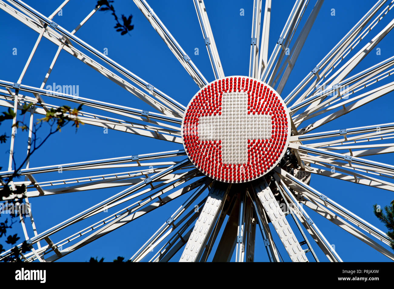 Nahaufnahme von einem Riesenrad in Genf, Schweiz, an der Runde Mittelteil aus rote und weiße Lichter in eine Schweizer Flagge konfiguriert. Stockfoto