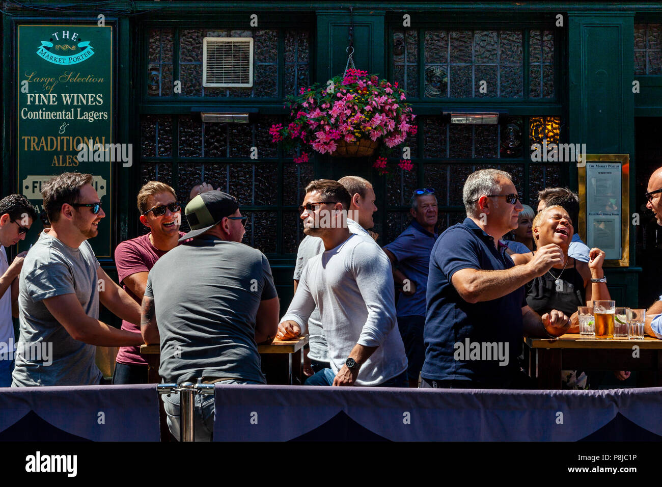 Glückliche, lachende Menschen genießen ein Mittagessen Zeit Trinken außerhalb des Marktes Porter Pub in der Borough Market, London, England Stockfoto