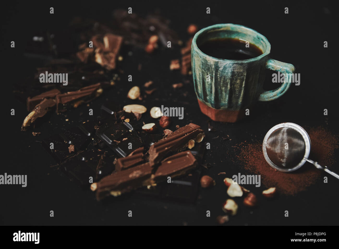 Schokoriegel auf dunklem Hintergrund mit Kaffee und Kakao Pulver zerkleinert. Closeup leckere Schokolade liebe Rahmen. Stockfoto