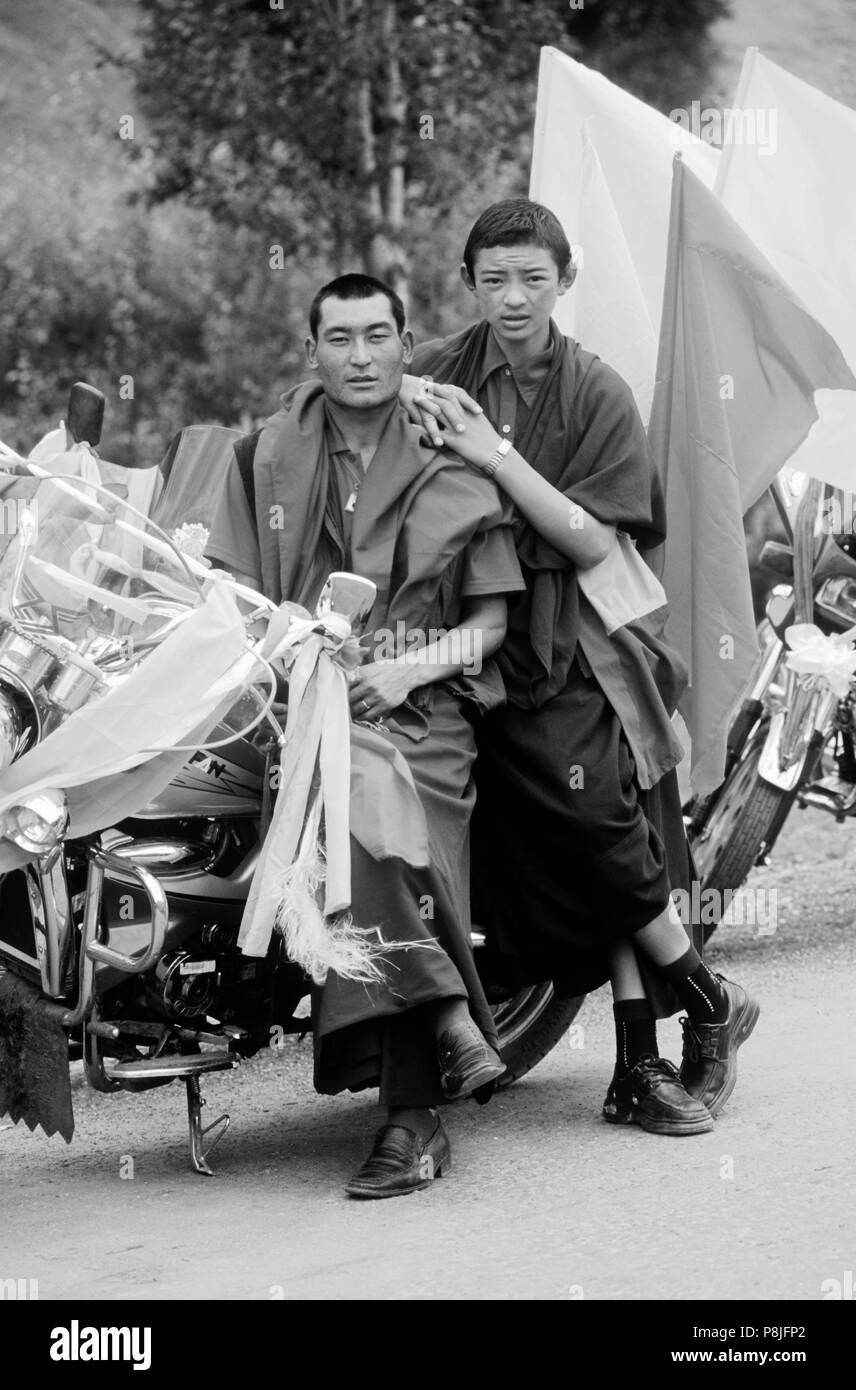 Buddhistische Mönche mit Motorrad mit katoks und Gebetsfahnen - Kham (E. eingerichtet Tibet), Provinz Sichuan, China Stockfoto