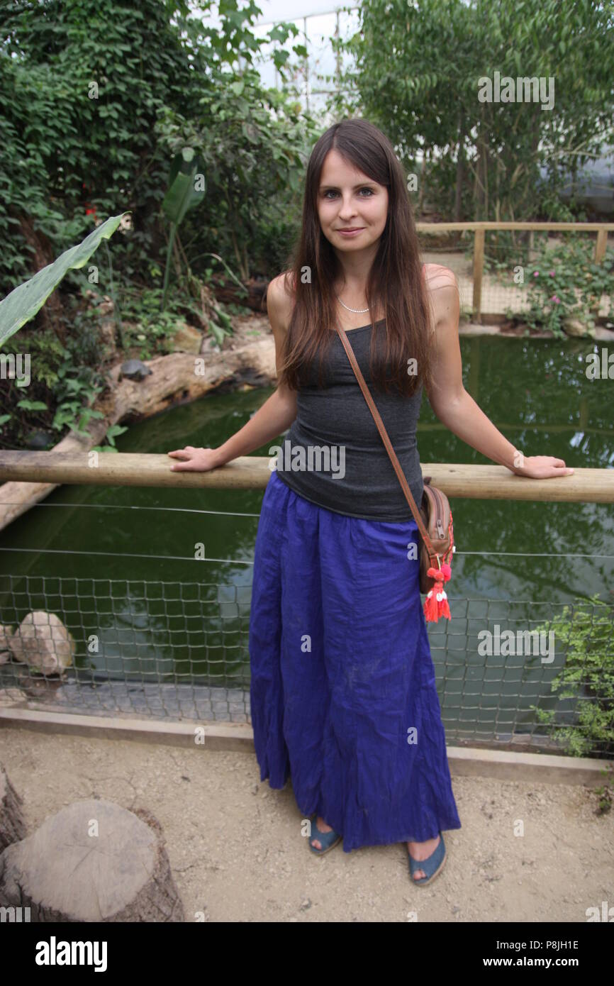 Schöne Russische Frau in Schwarz Weste und Blau langer Rock lächelnd Stockfoto