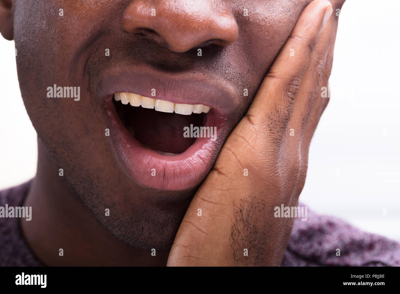 Nahaufnahme eines Mannes mit Zahnschmerzen vor weißem Hintergrund Stockfoto