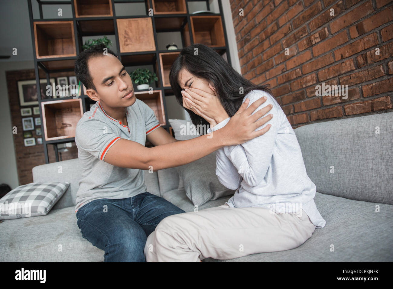 Junger Mann beruhigend Weinen traurige Frau, fürsorglichen Mann mit Empathie und Unterstützung in Beziehungen Konzept Stockfoto