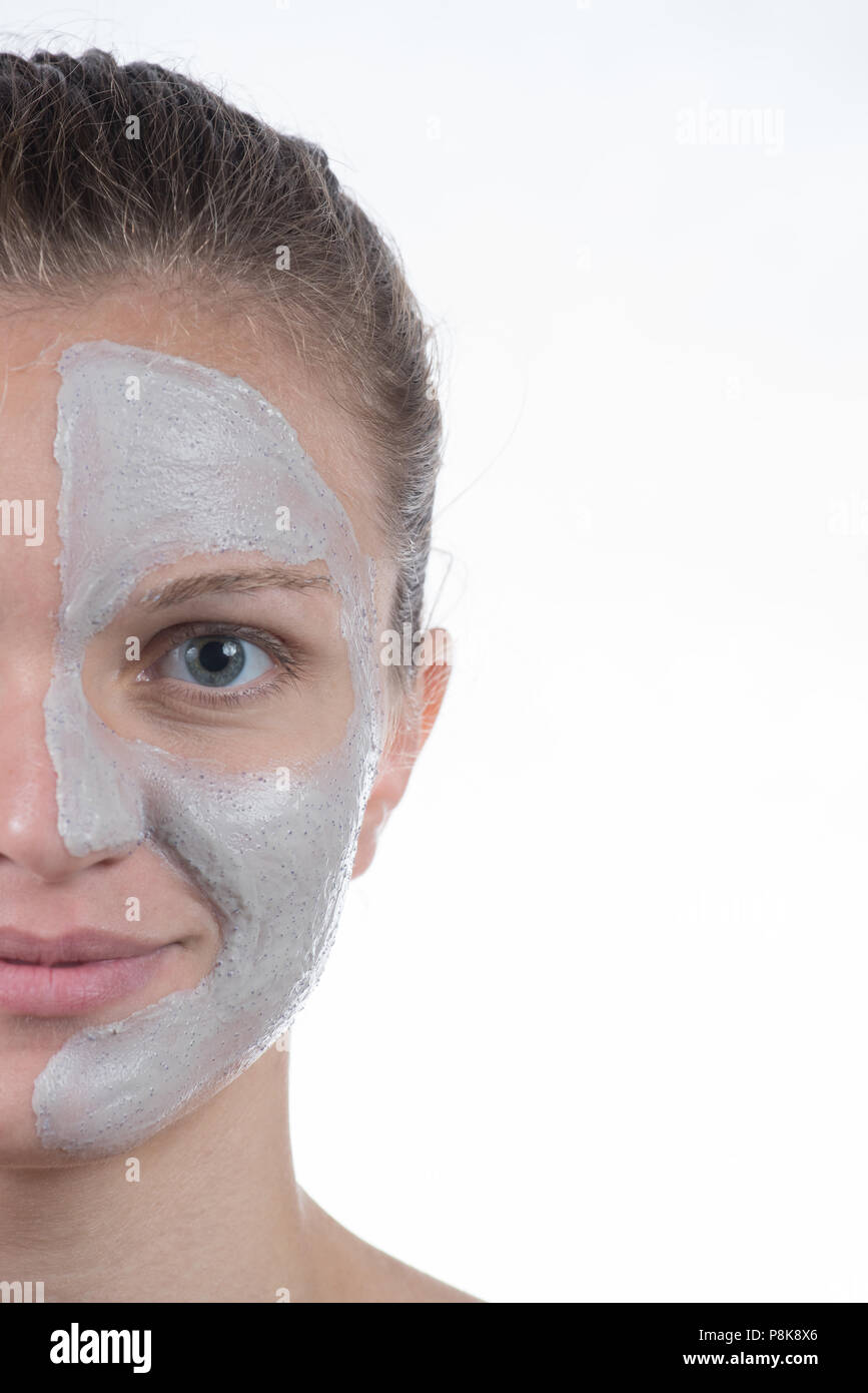 Kosmetische Maske der grauen Ton mit Gestrüpp auf dem Gesicht eines schönen jungen Mädchen auf weißem Hintergrund Stockfoto