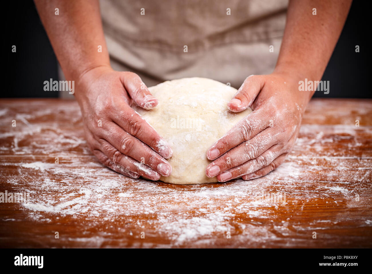 Baker Hände, sauerteigbrot auf einem Holztisch Stockfoto