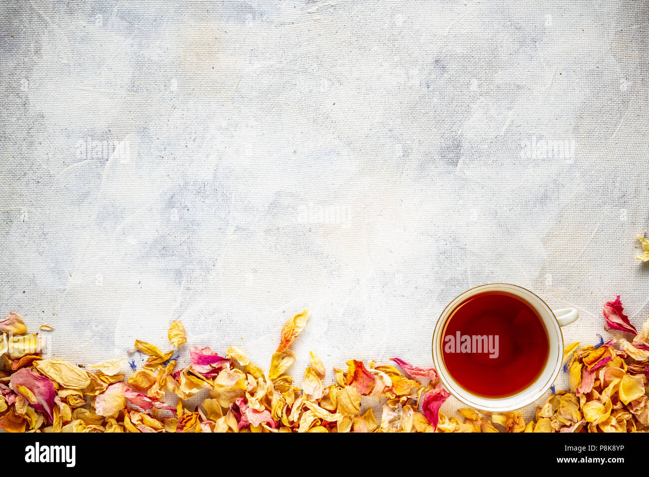 Rahmen der getrockneten wild rose Blumenblätter und Tasse Tee, kopieren Raum Stockfoto