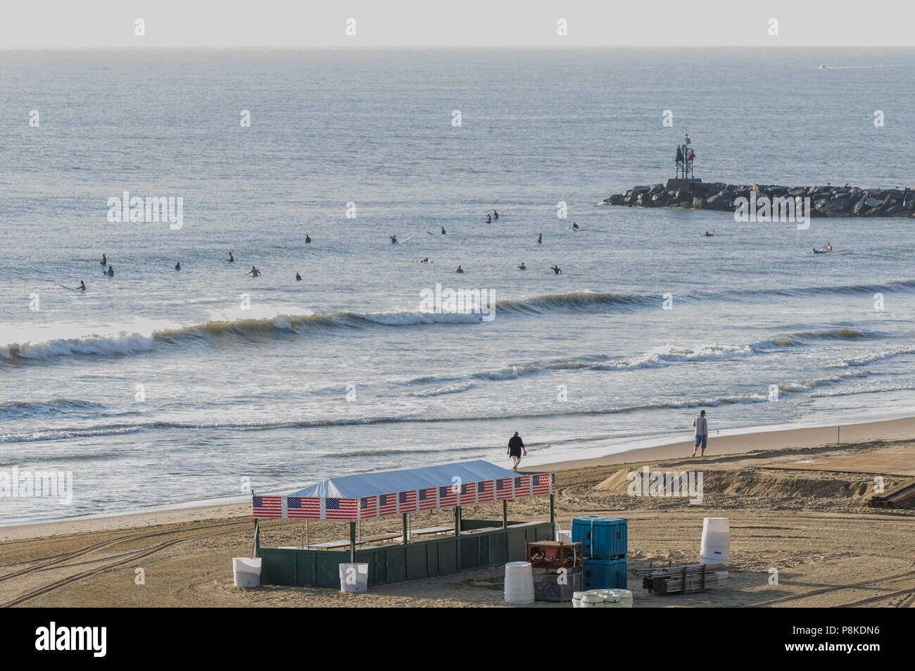 Virginia Beach, VA - 31. August 2017: Surfer Schwimmen in der Brandung bei Sonnenaufgang am Virginia Beach, VA. Stockfoto