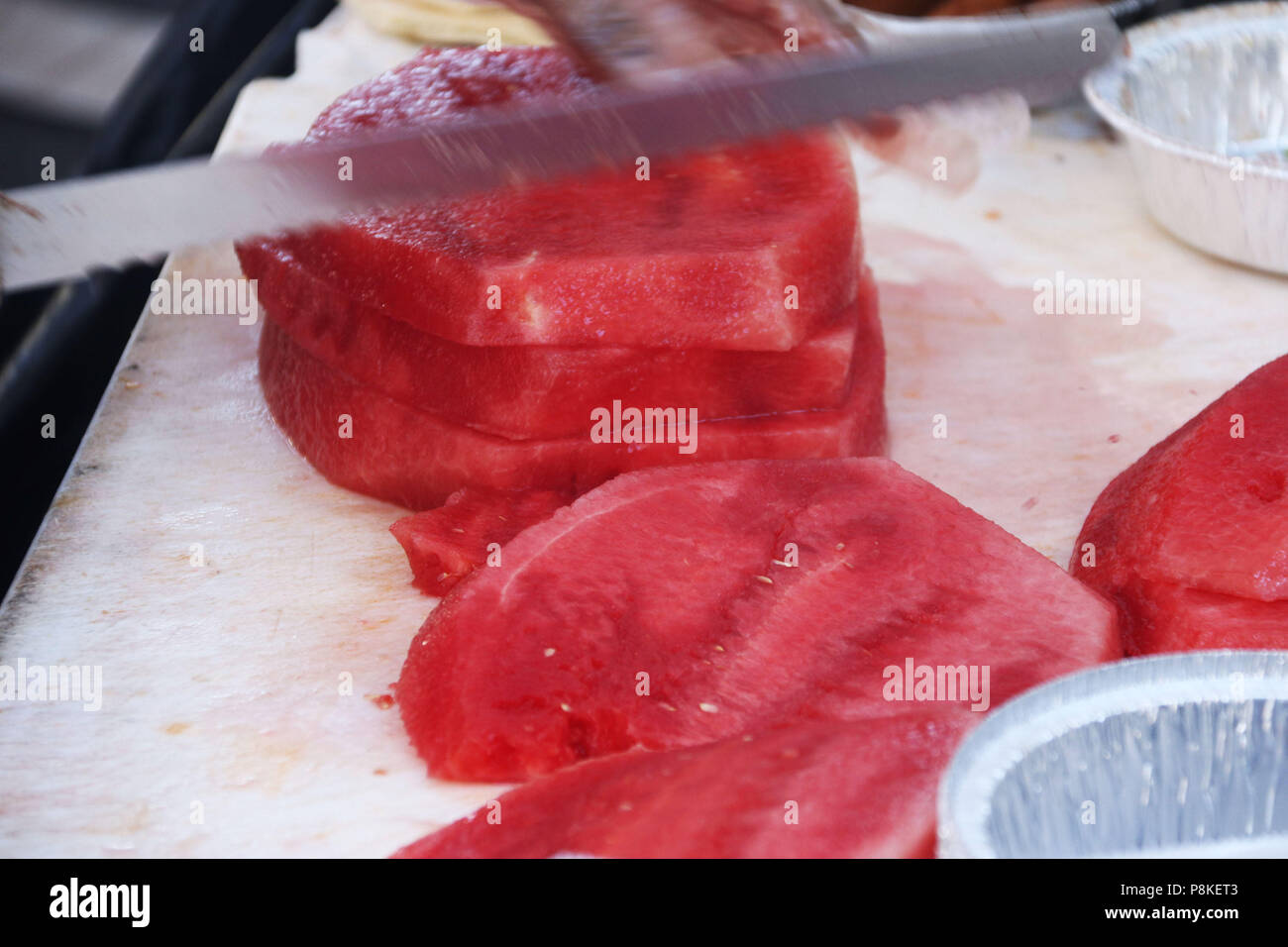 Ganze Wassermelone in Scheiben geschnitten mit einem Messer Stockfoto